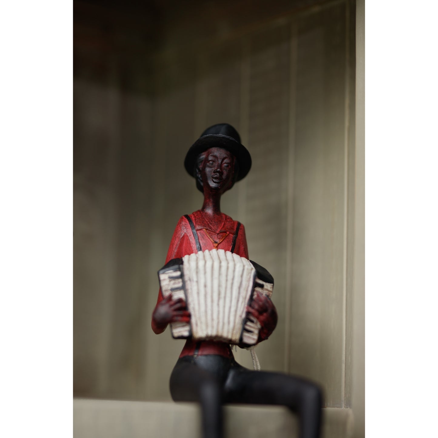 Sitting jazz band figurine in red, featuring a musician with an accordion, showcasing elegant detailing and vintage charm.