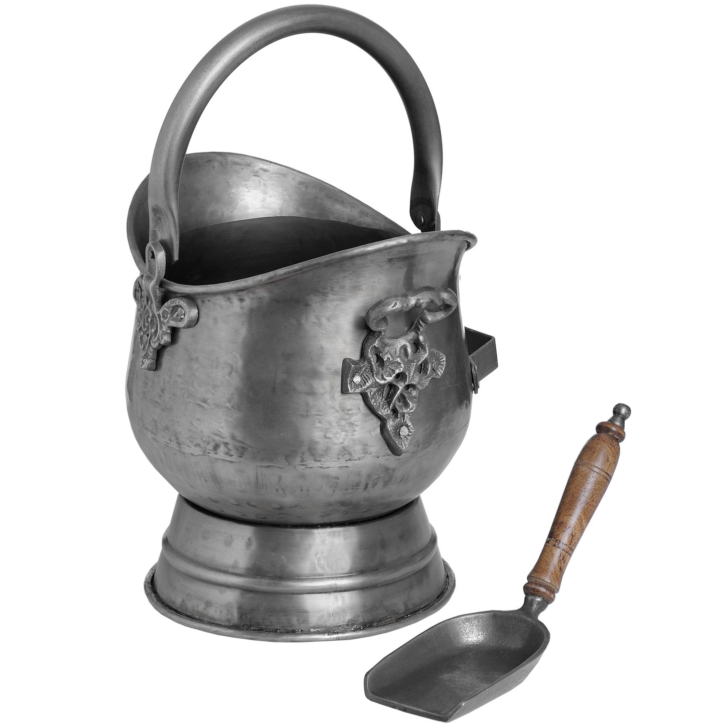 Antique pewter coal bucket with intricate floral embossing, curved handle, and a wooden-handled shovel beside it, exuding vintage charm.