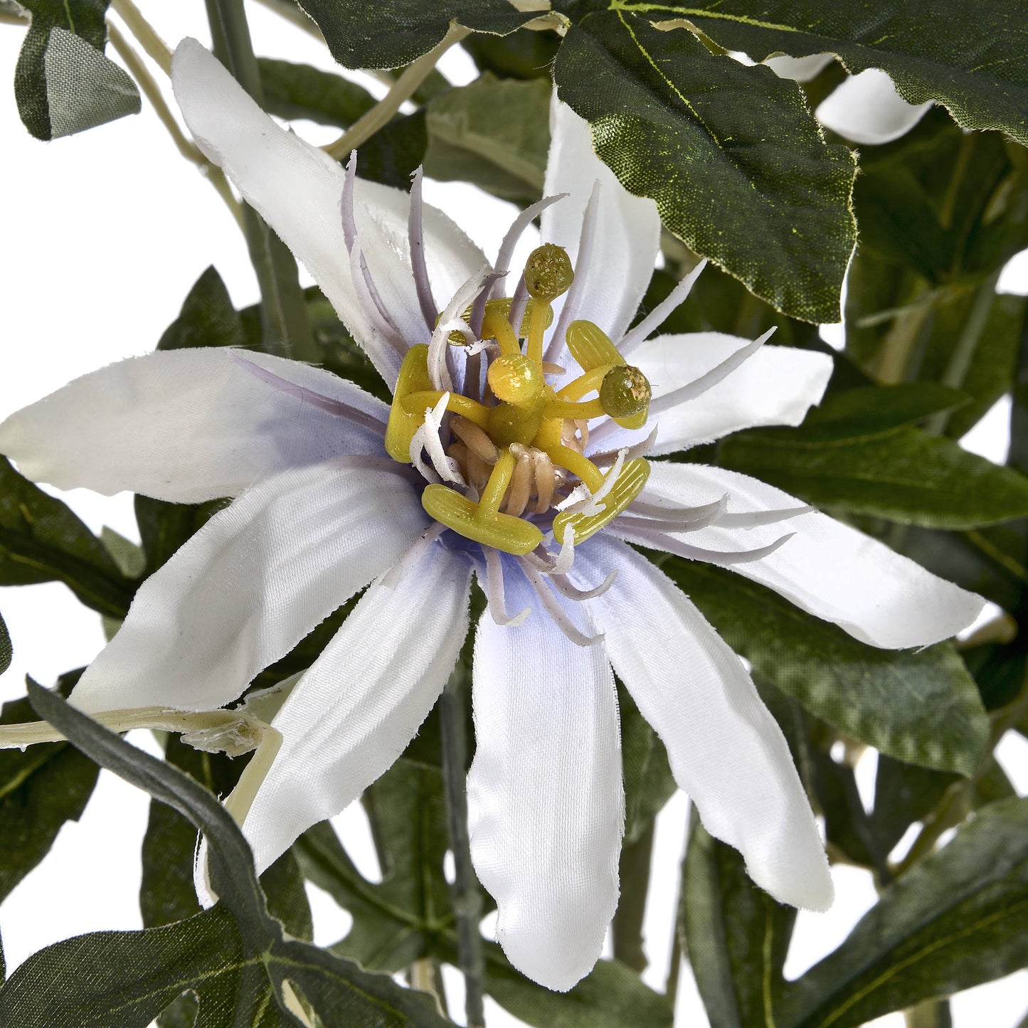 Lifelike Passion Flower Spray features elegant white petals and intricate yellow center details, surrounded by lush green leaves.