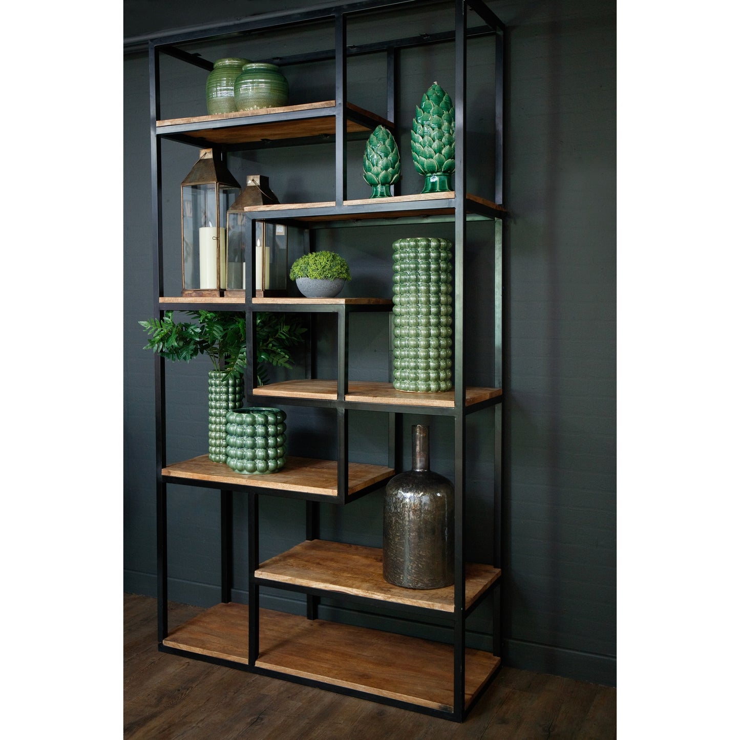 Industrial-style shelf unit featuring six wooden shelves with a black metal frame, adorned with green decorative vases and plants.
