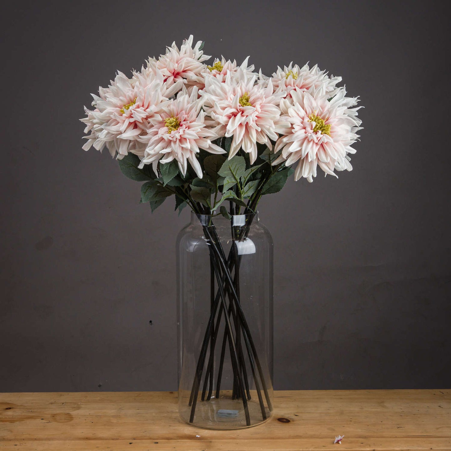 Lush pink dahlia artificial flowers in a clear vase, showcasing lifelike petals and green foliage for elegant decor.