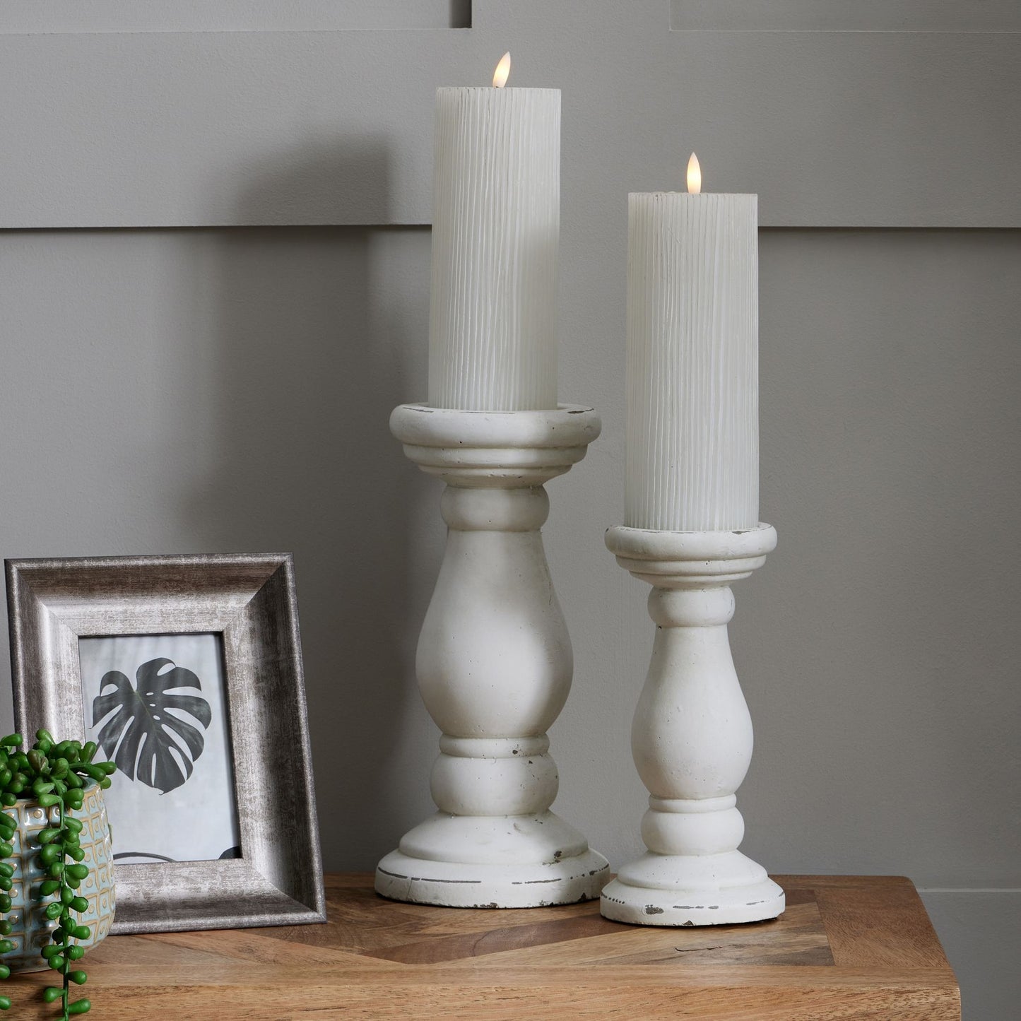 Convex 5x7 frame with a distressed silver finish, accented by white candles, showcasing a leaf silhouette behind glass.