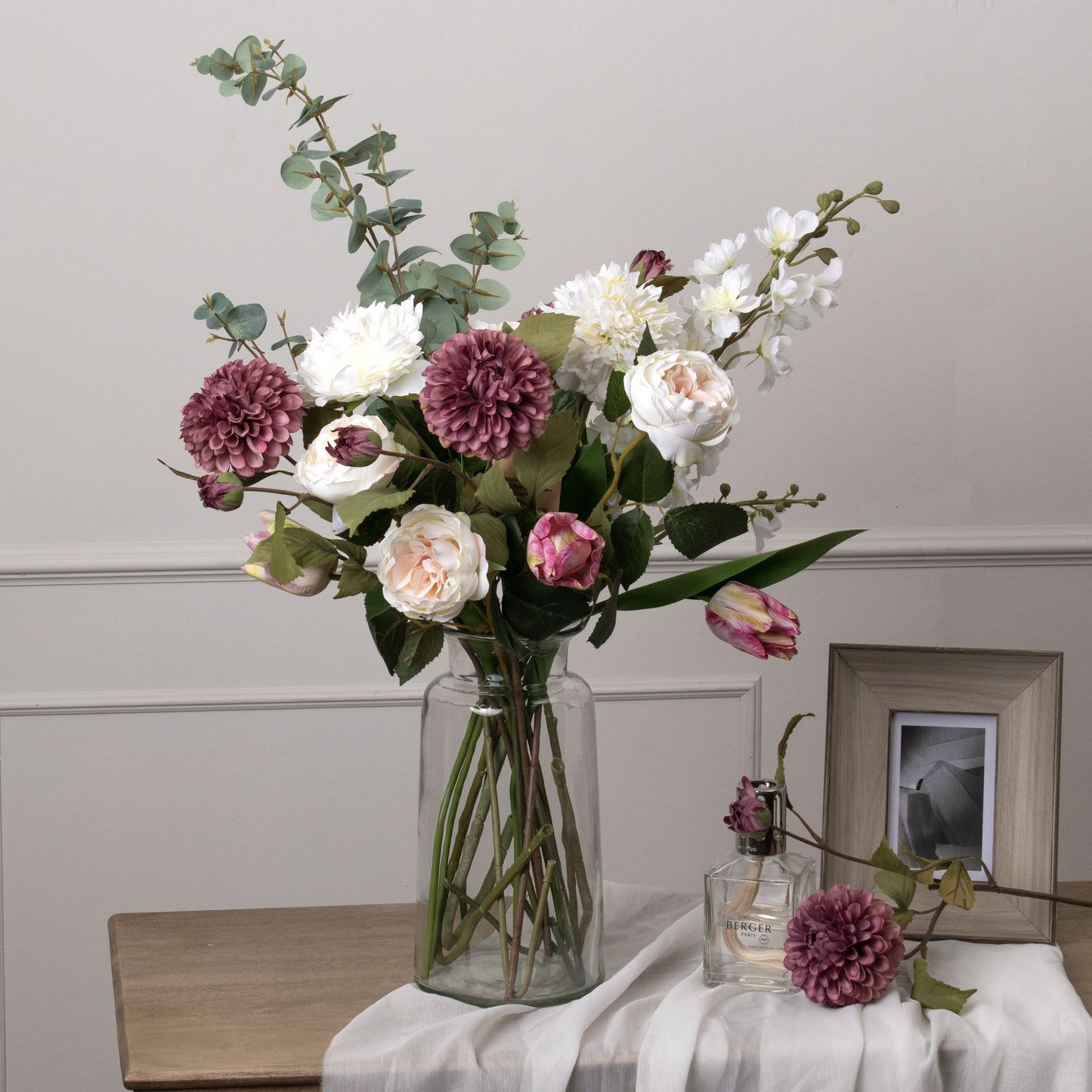 Large green cineraria eucalyptus spray adds realistic greenery to floral arrangements, complementing vibrant blooms in a glass vase.