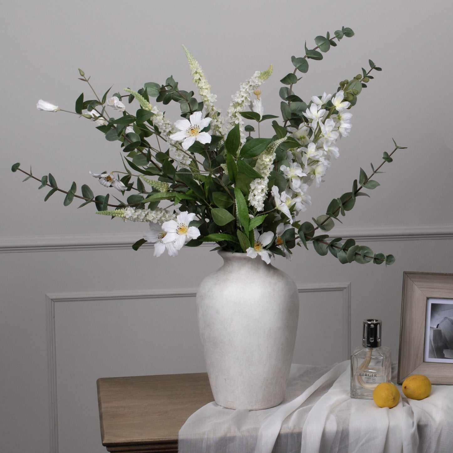 Large cineraria eucalyptus spray in green, featuring realistic leaves and white blooms in a textured vase, perfect for elegant decor.