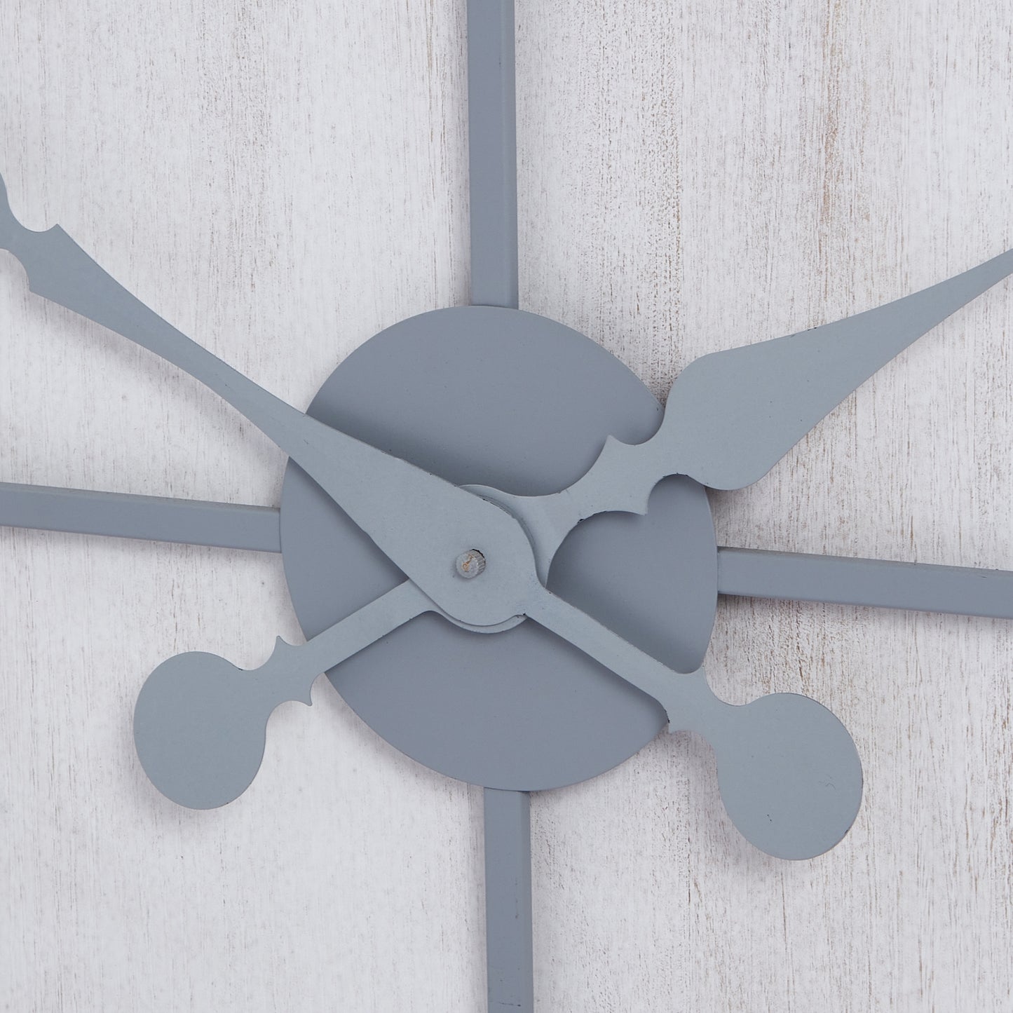 Multi-paneled wall clock with sleek gray hands, set against a textured white background, combining modern elegance and functionality.