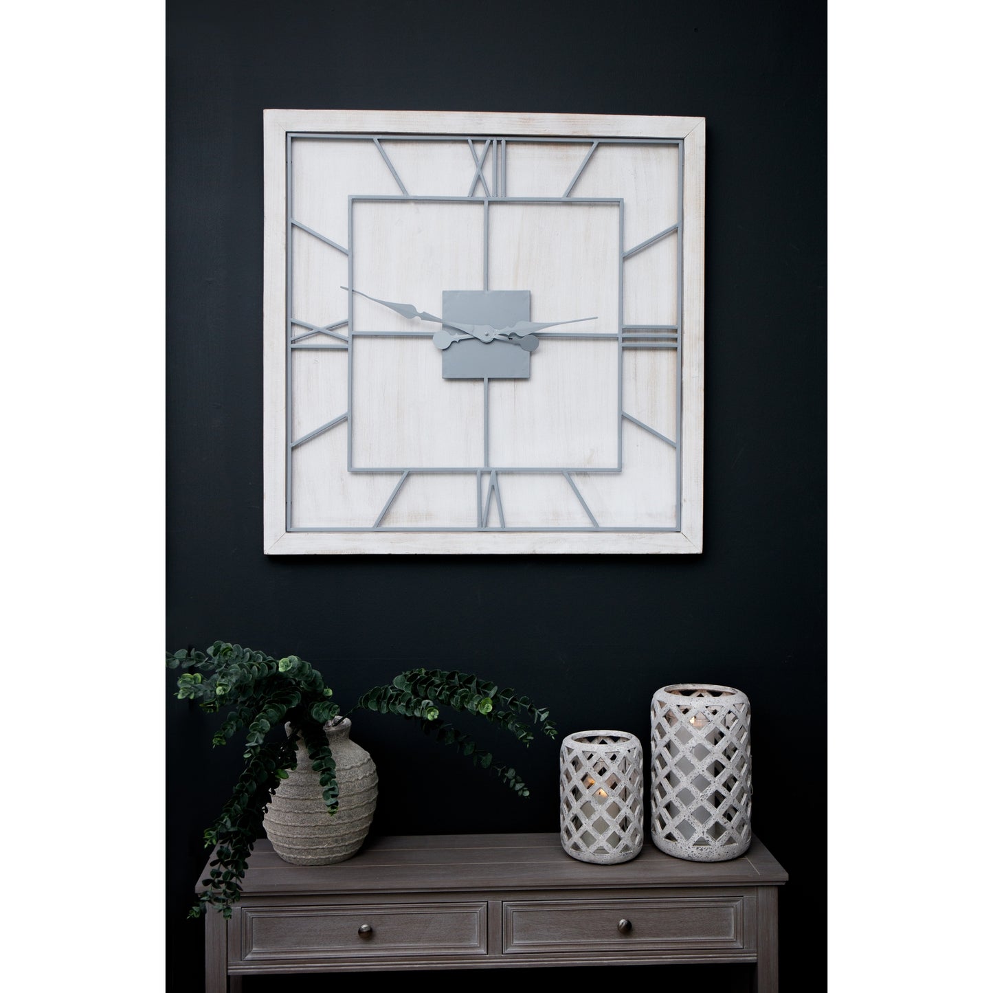 White square wall clock featuring a white-washed wooden frame, light grey Roman numerals, and an open skeleton-style design.