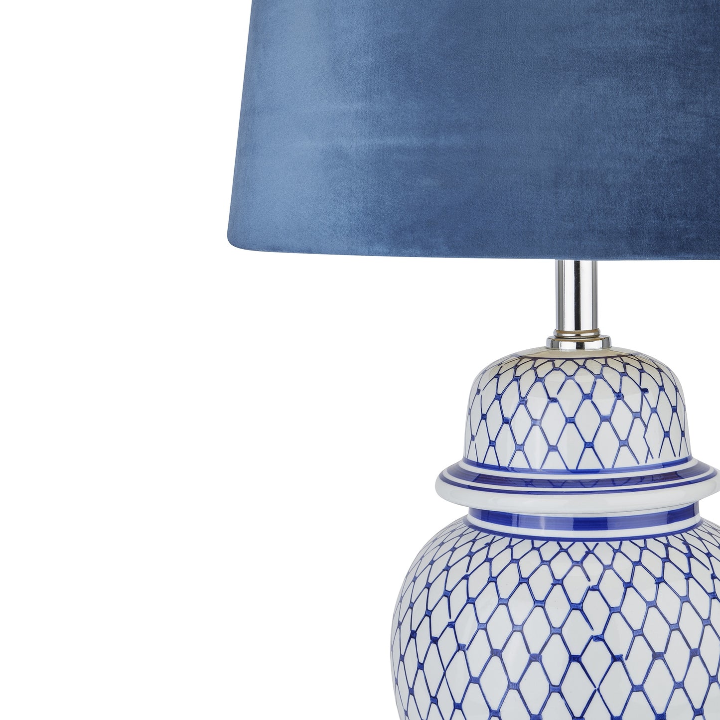 Ceramic lamp with intricate blue and white patterns, topped with a luxurious blue velvet shade, showcasing elegant craftsmanship.