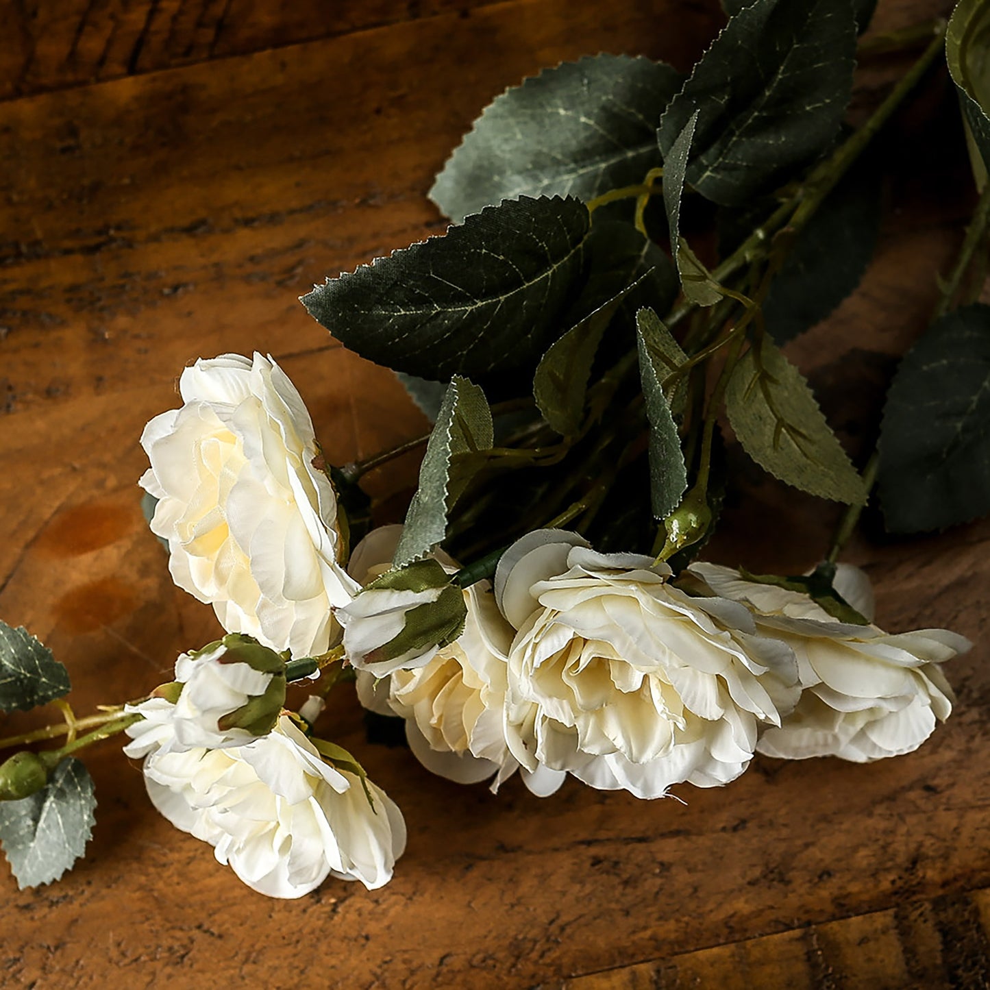 Lifelike soft white cottage rose stem with lush green leaves, perfect for adding elegance to any decor.