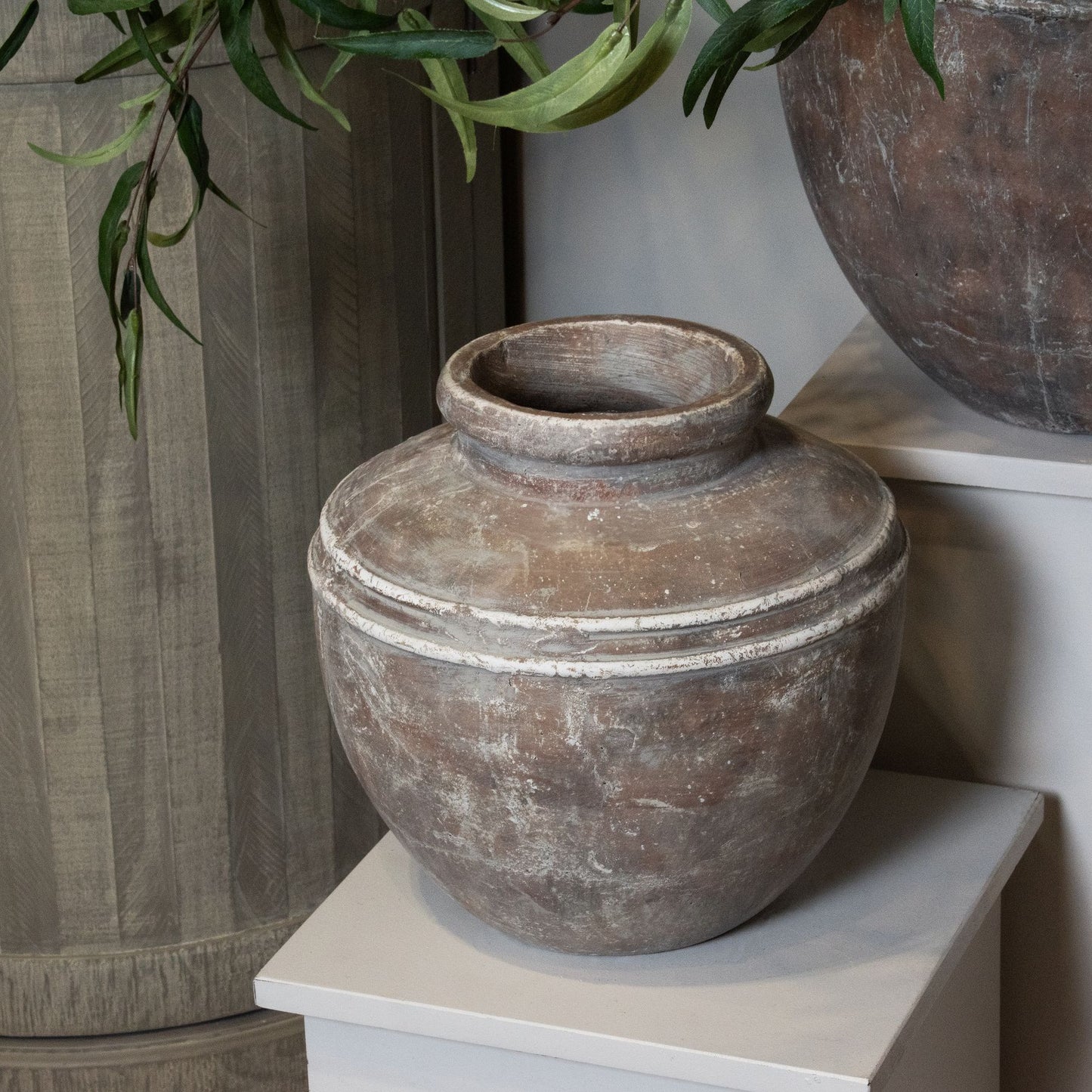 Distressed brown ceramic water pot with an urn shape and textured finish, perfect for indoor plants or decorative display.