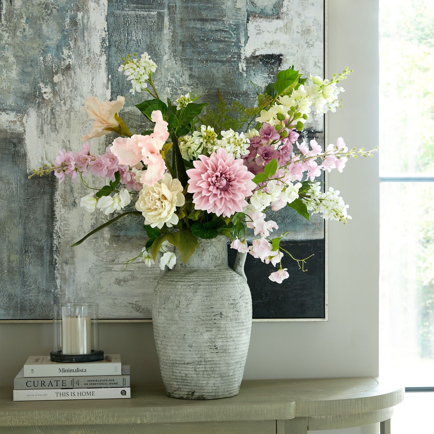 Artificial white lilac stem among pastel flowers in a textured vase, enhancing a sophisticated interior with elegant detail.