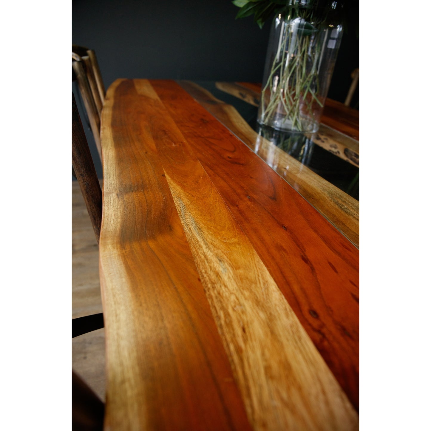 Large live edge dining table made from solid Acacia wood, featuring a glass river inlay and warm, natural tones, enhancing sophistication.