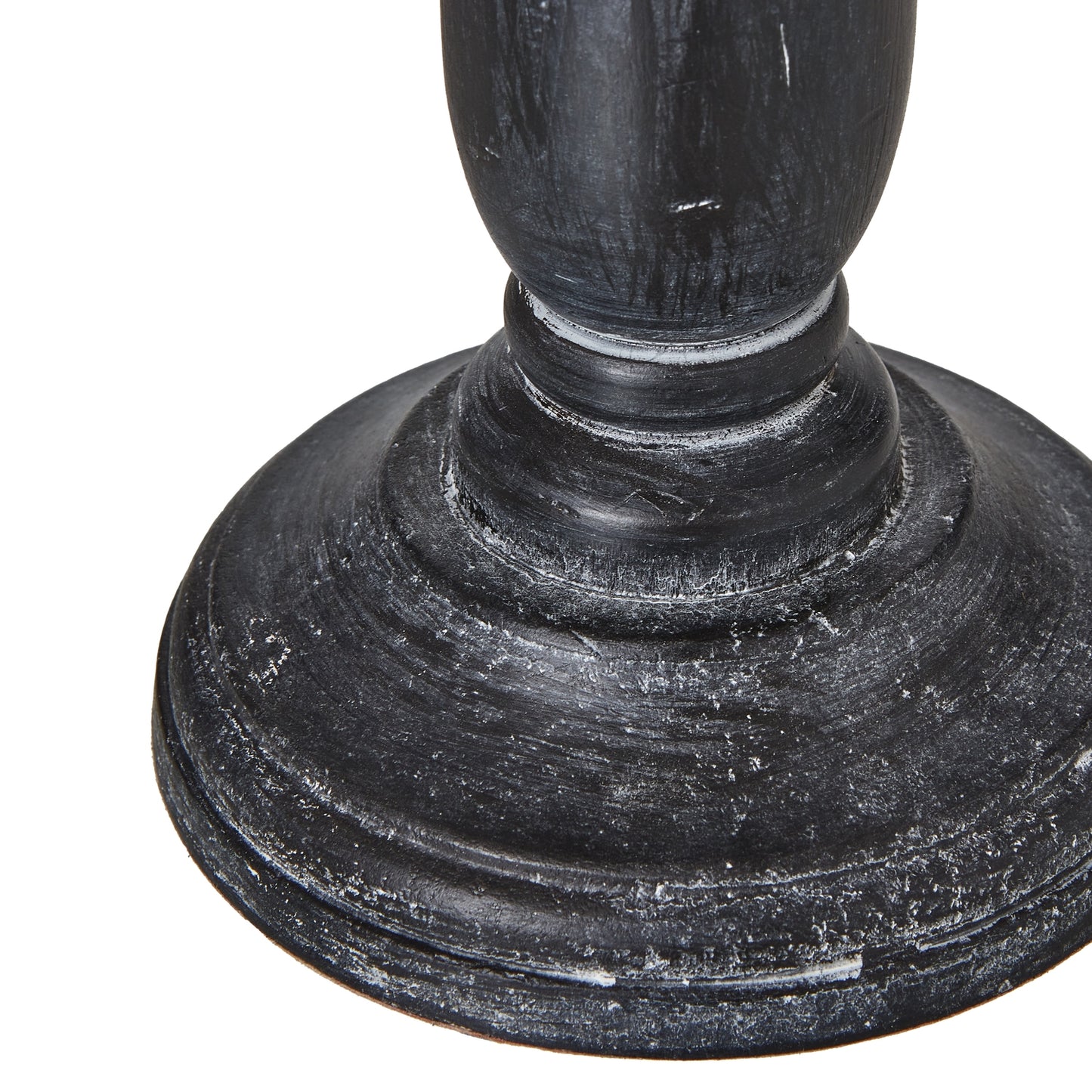 Distressed black base with intricate contours supports a neutral linen shade, creating a sophisticated tabletop lamp.
