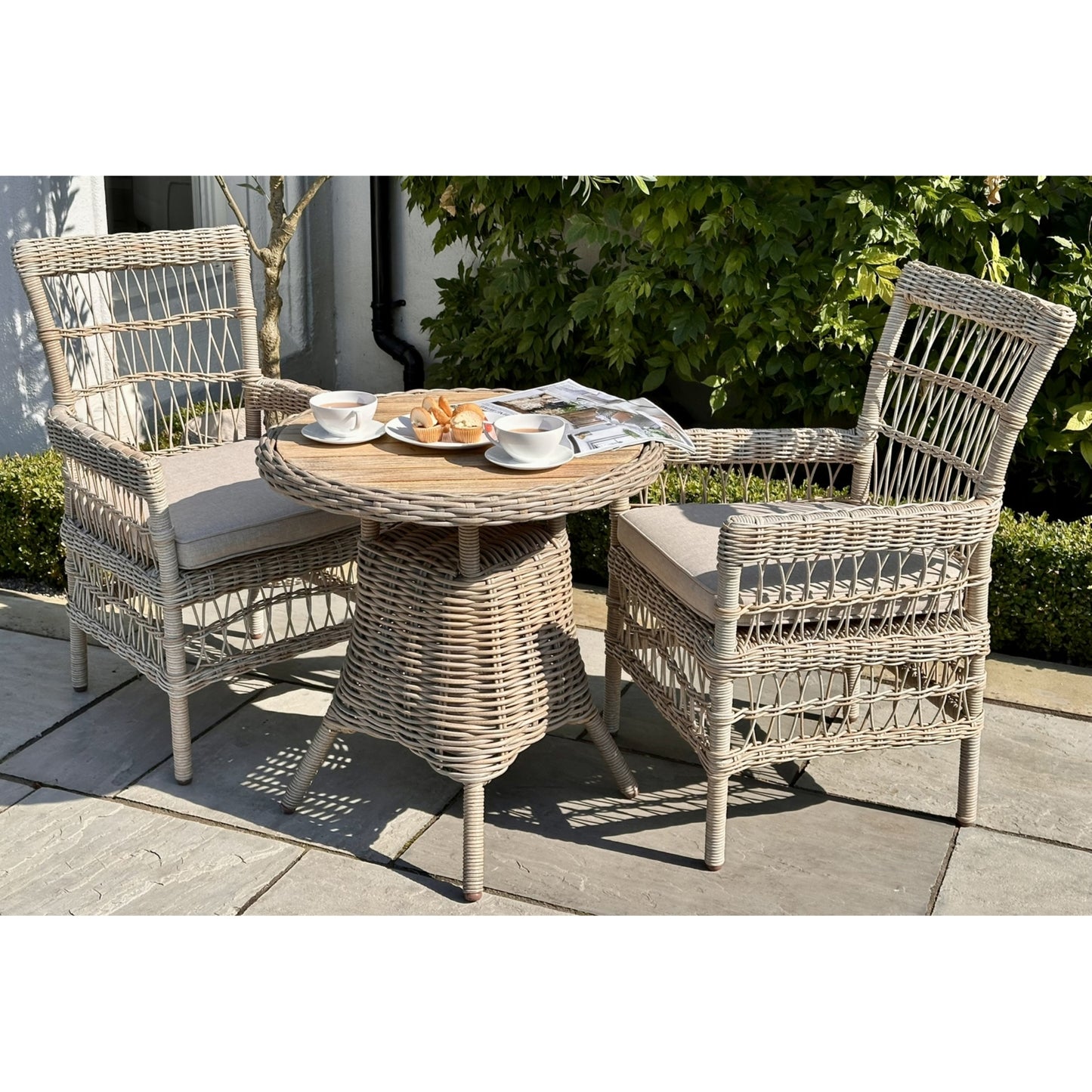 Elegant outdoor bistro table with a warm wood top, surrounded by stylish woven chairs, ideal for intimate gatherings.