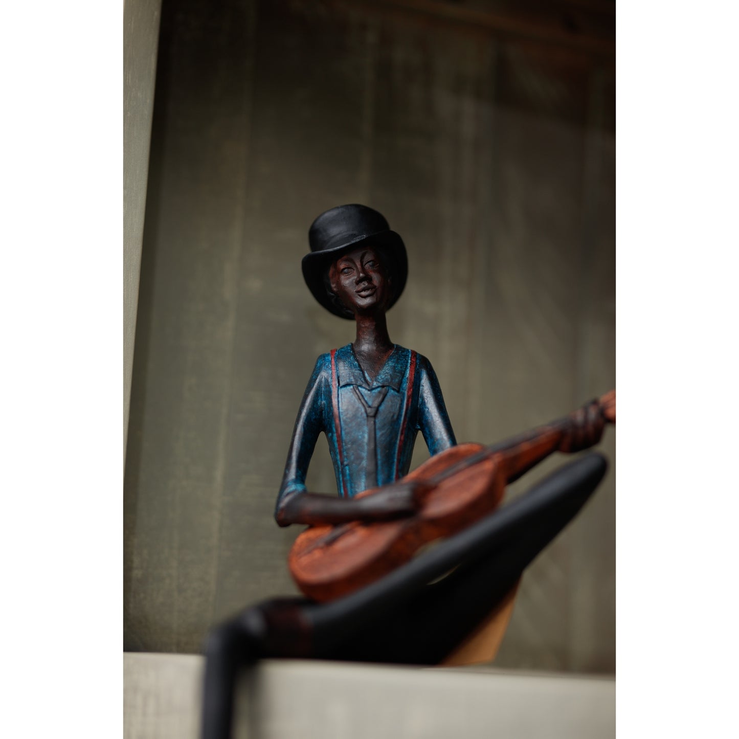 Sitting Jazz Band Strings figurine features a detailed musician in a blue outfit and black hat, playing guitar with an artful, elegant design.