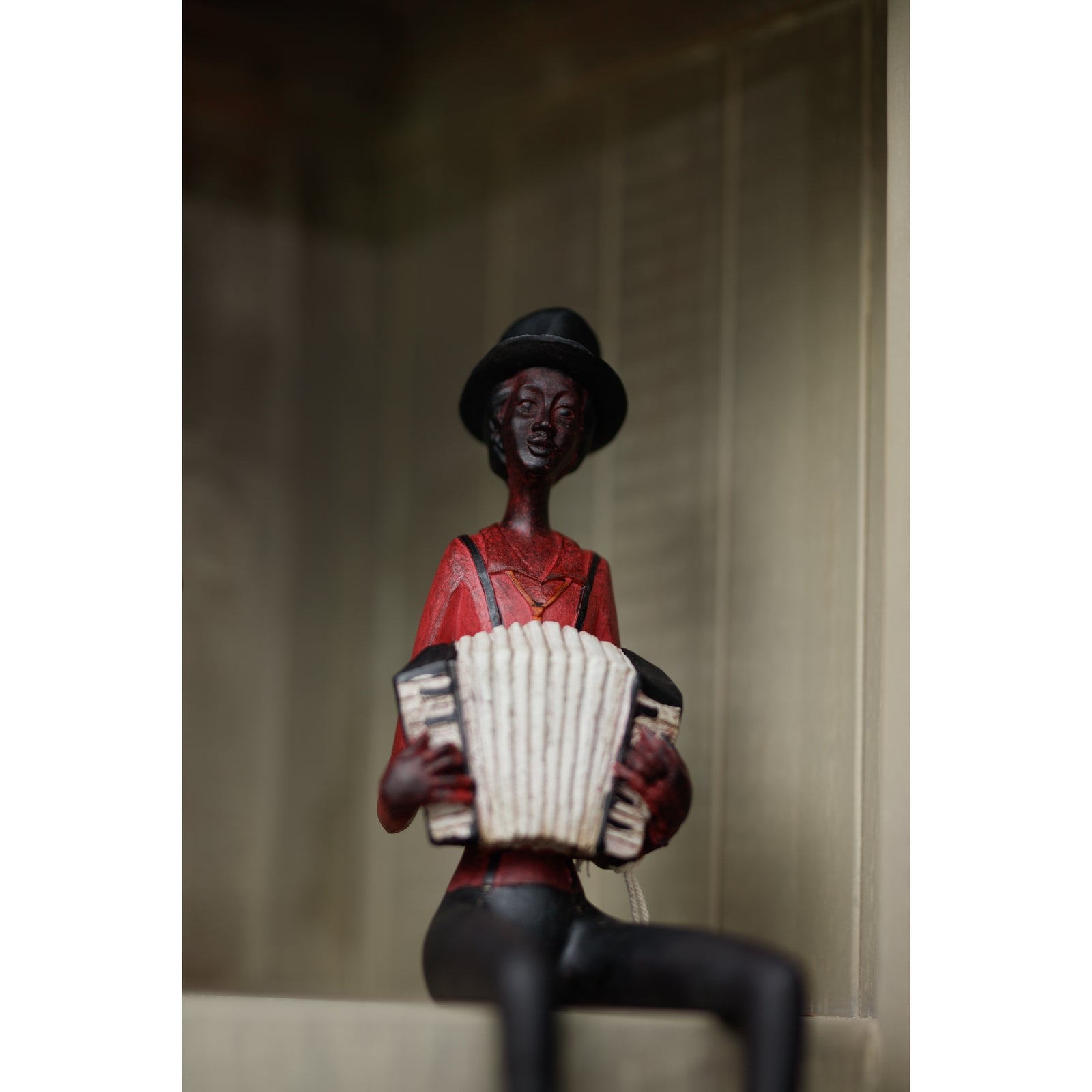 Sitting jazz band figurine in red, featuring a musician with an accordion, showcasing elegant detailing and vintage charm.