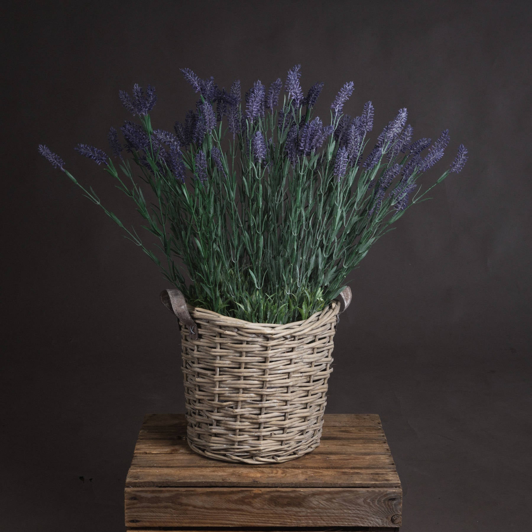 Large lavender spray in a wicker basket, featuring vibrant purple blooms and lush green foliage, creating a serene decor accent.