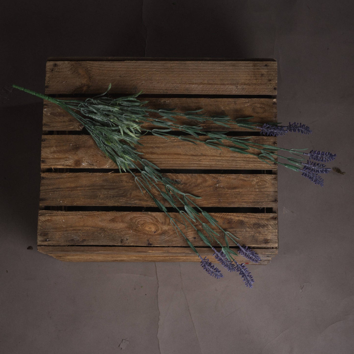 Large lavender spray with nine purple blooms and green foliage, elegantly arranged on a rustic wooden surface.