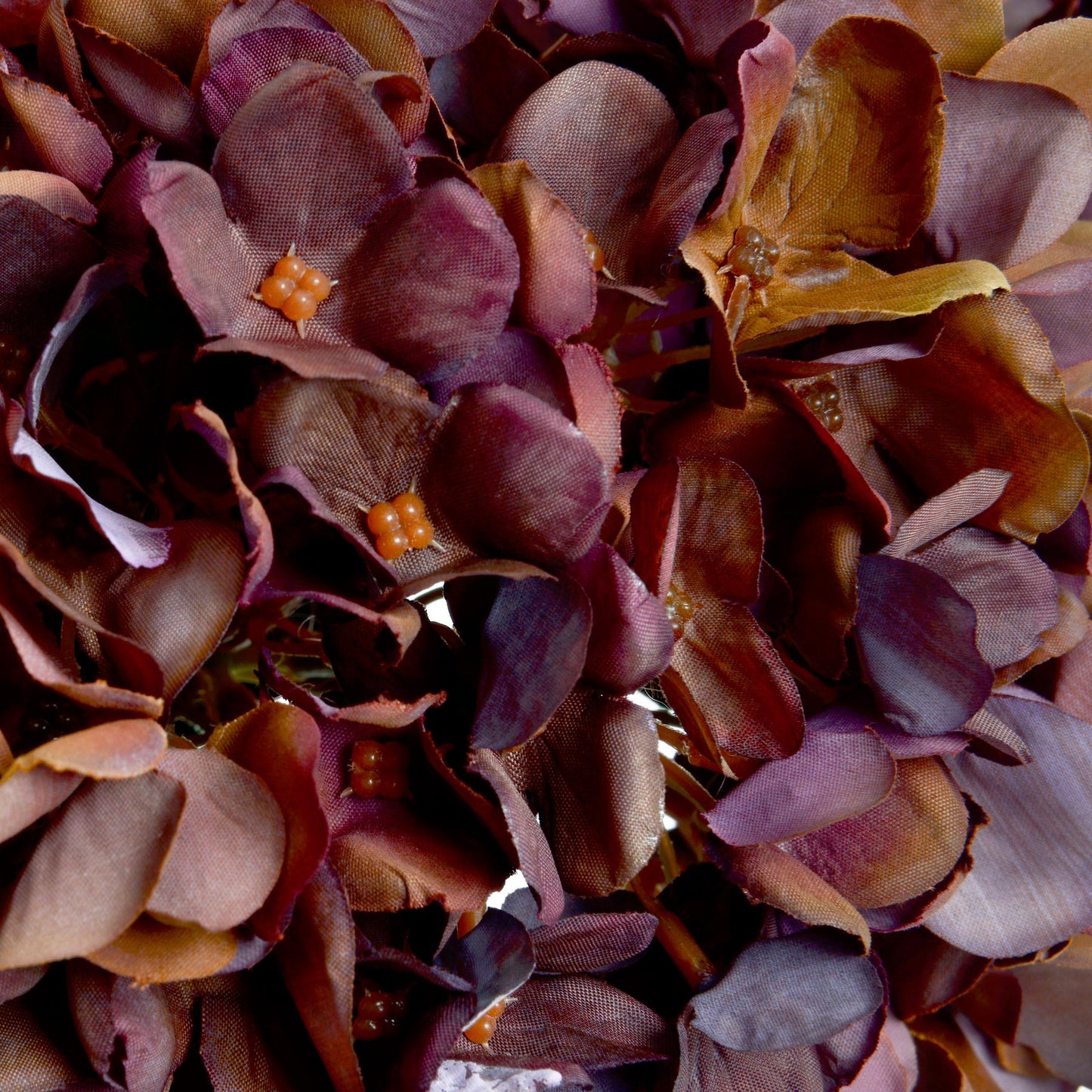 Lifelike hydrangea stem in rich coffee tones, featuring detailed petals and a flexible wired stem for versatile decor styling.