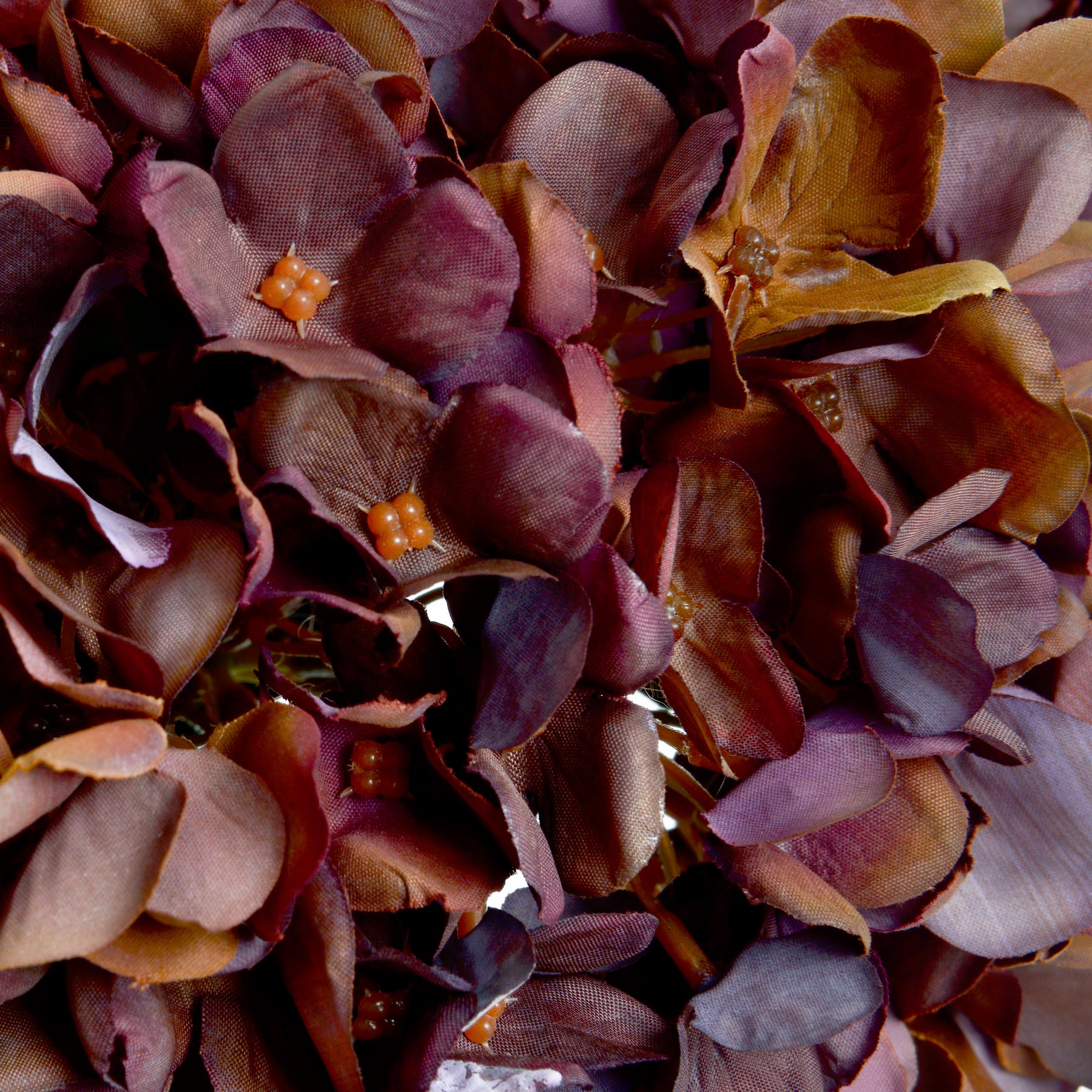 Lifelike hydrangea stem in rich coffee tones, featuring detailed petals and a flexible wired stem for versatile decor styling.