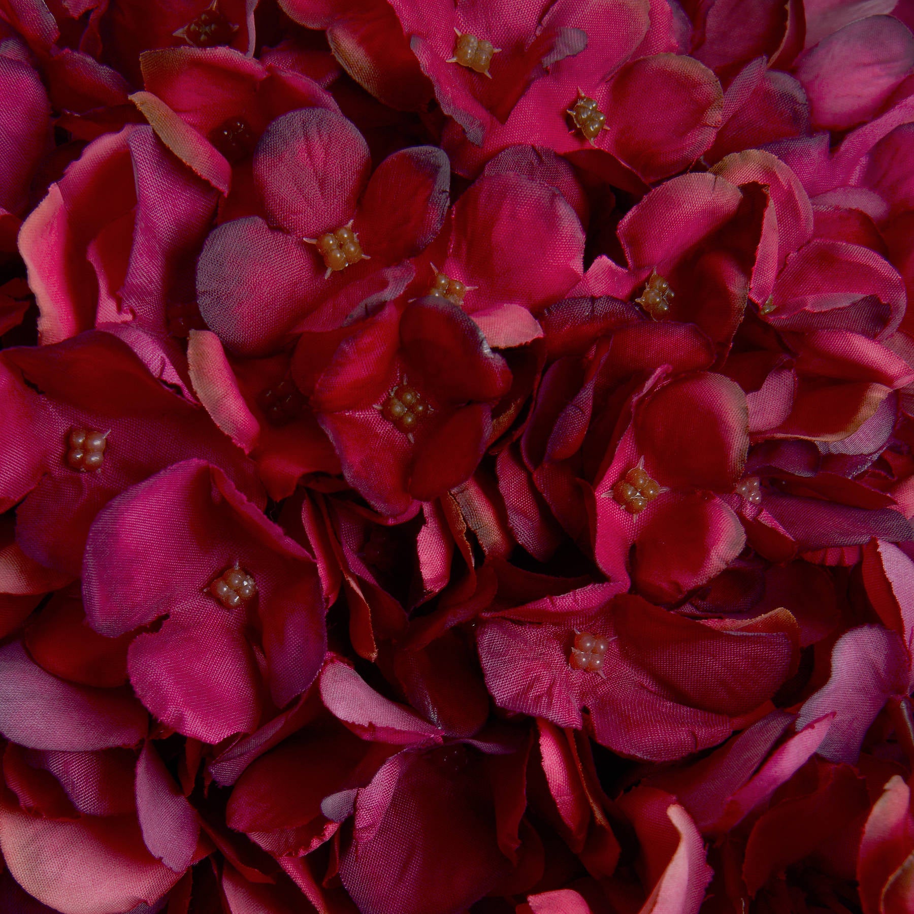 Richly detailed, deep ruby artificial hydrangea petals create a warm, sophisticated autumn accent for decor.