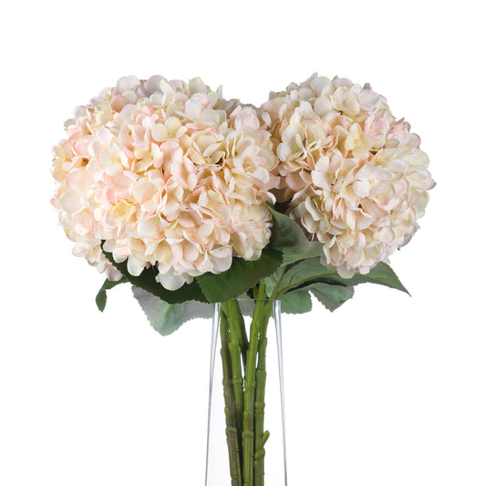 White hydrangea stems with hand-painted petals and subtle blush undertones, featuring lush green leaves for seasonal elegance.