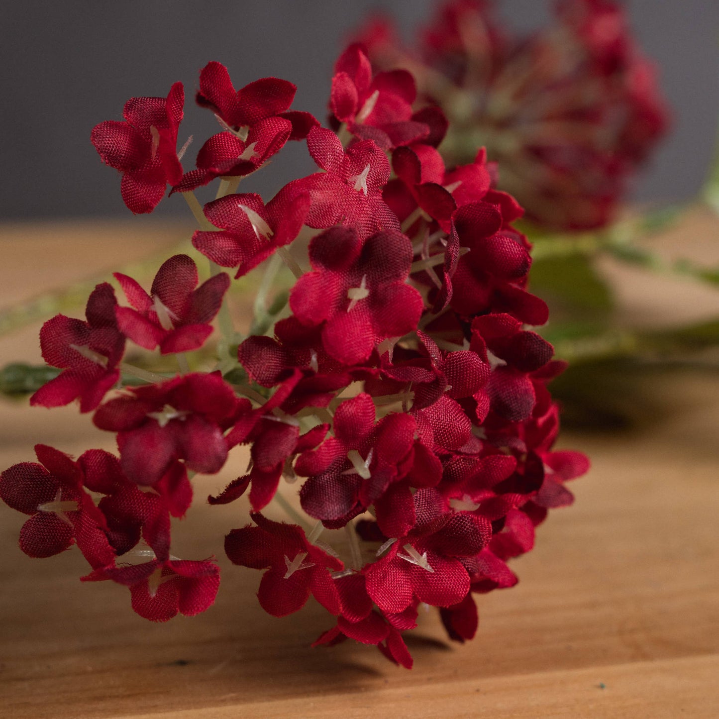 Crimson artificial viburnum stems feature densely clustered flowers, ideal for elegant autumn displays and decorations.