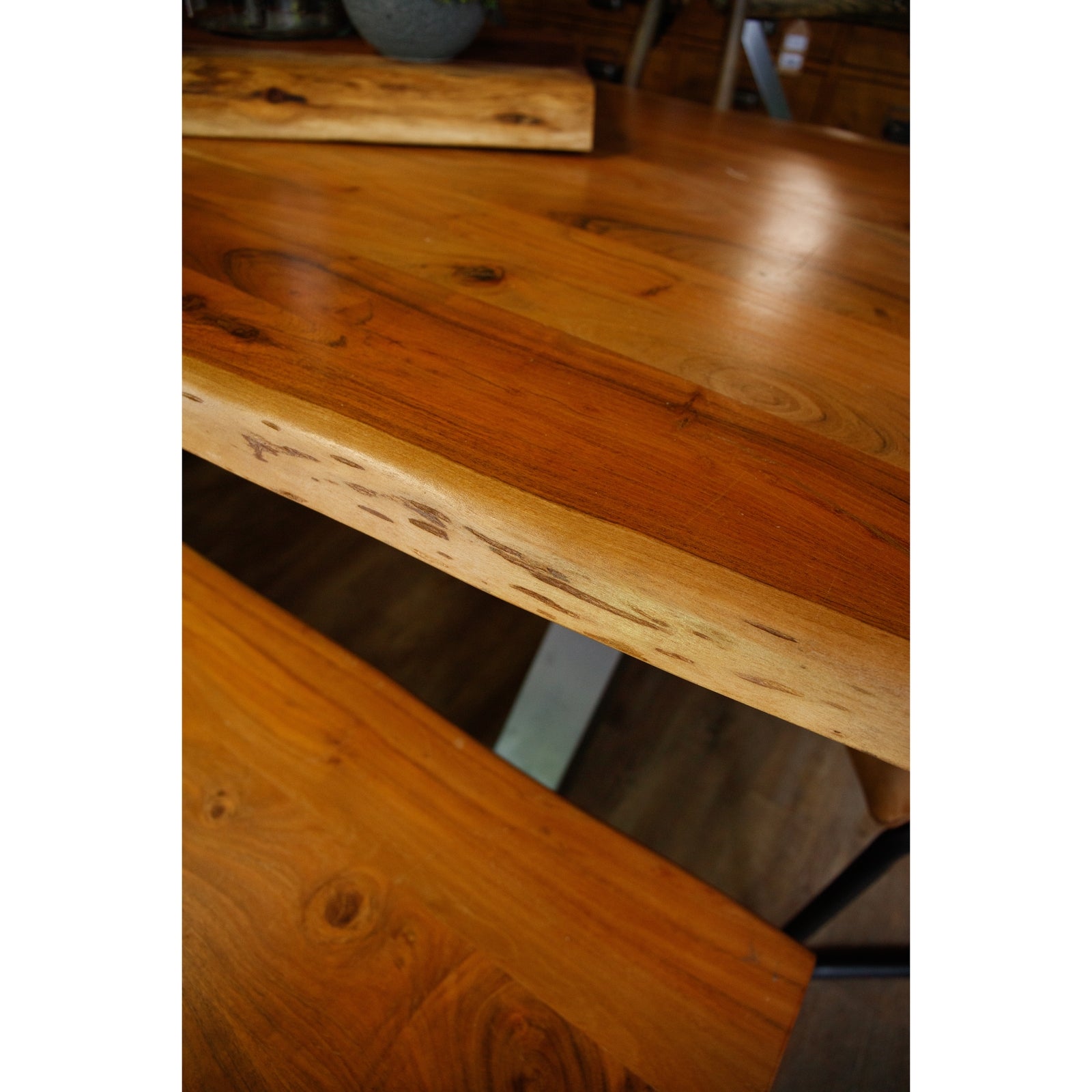 Natural acacia wood dining table featuring unique live edge detail, paired with a sleek grey metal frame for rustic elegance.