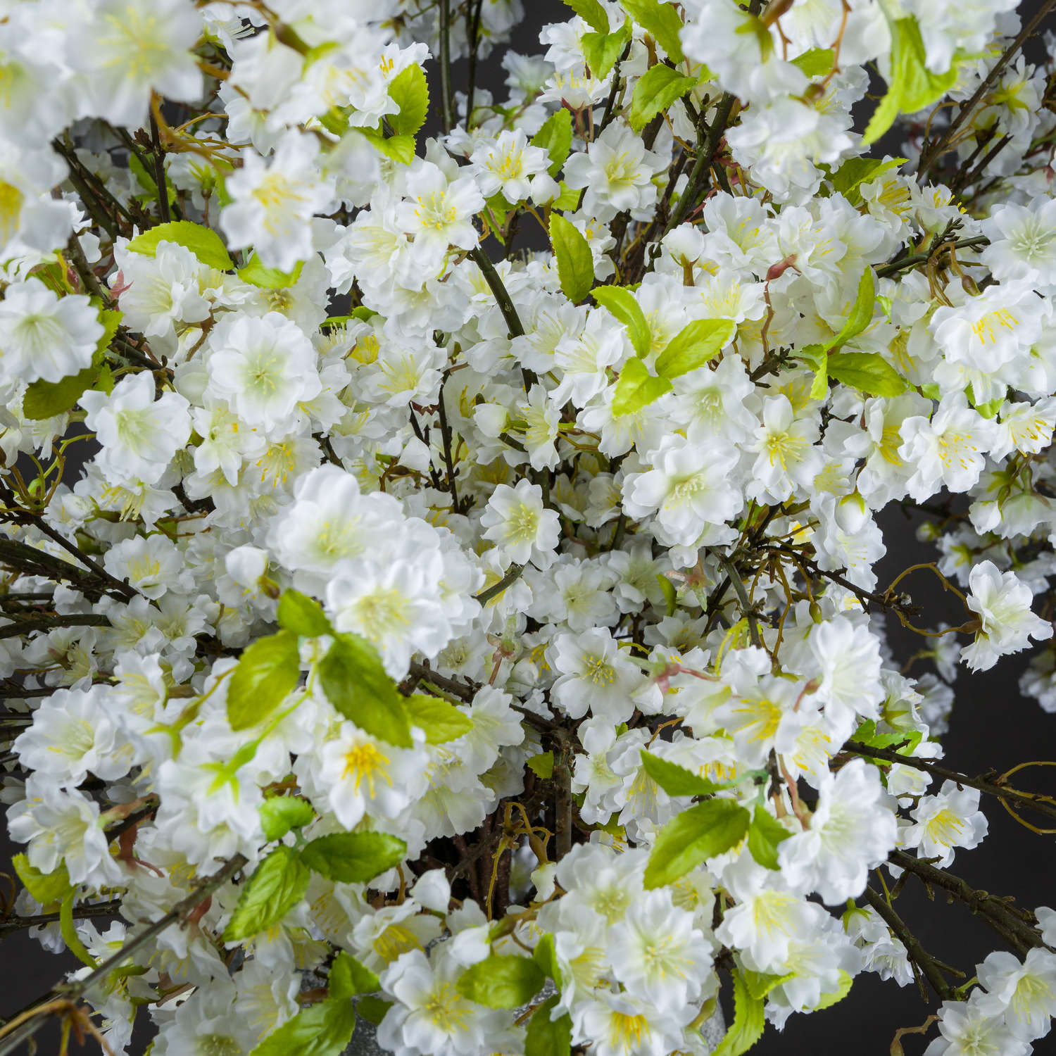 Lifelike white cherry blossoms with green leaves, creating a fresh, elegant accent suitable for any decor style.
