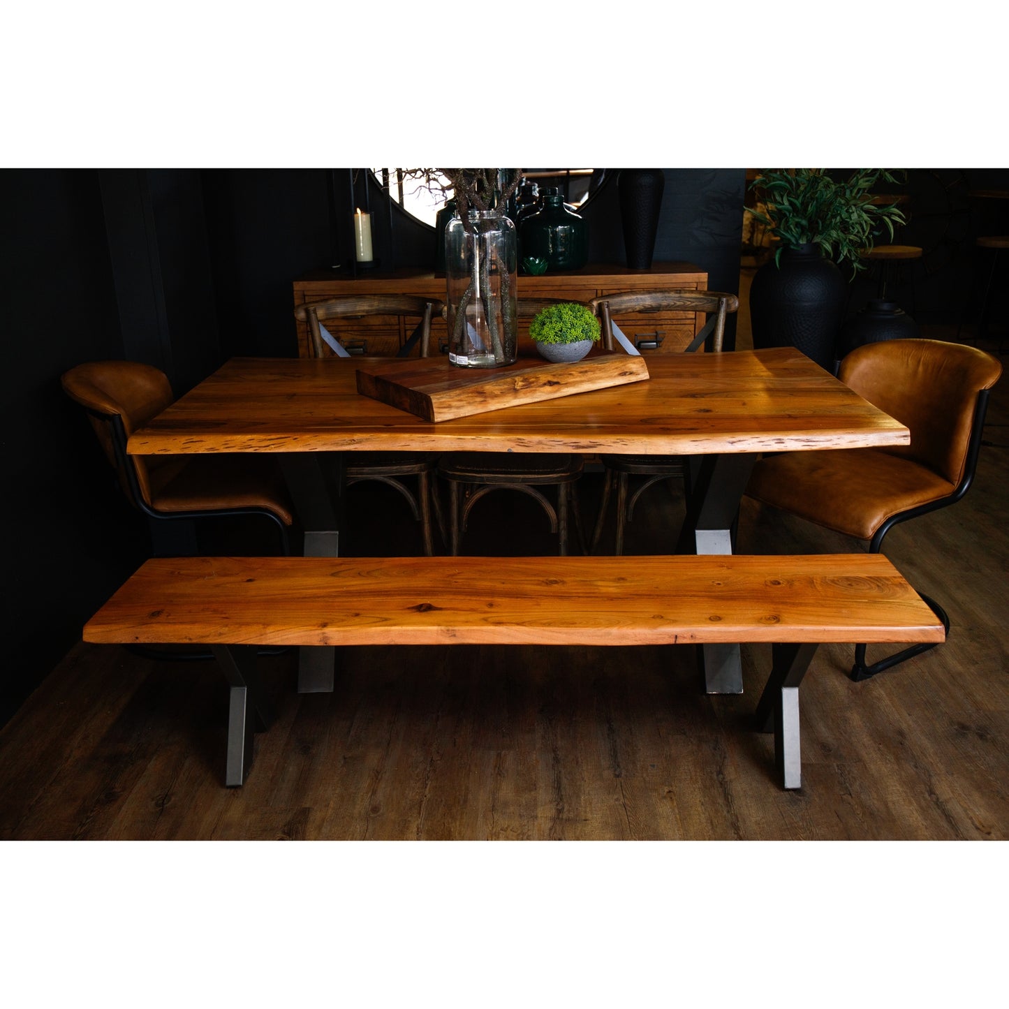 Large live edge dining table made of Indian acacia wood with industrial metal legs, surrounded by stylish seating.