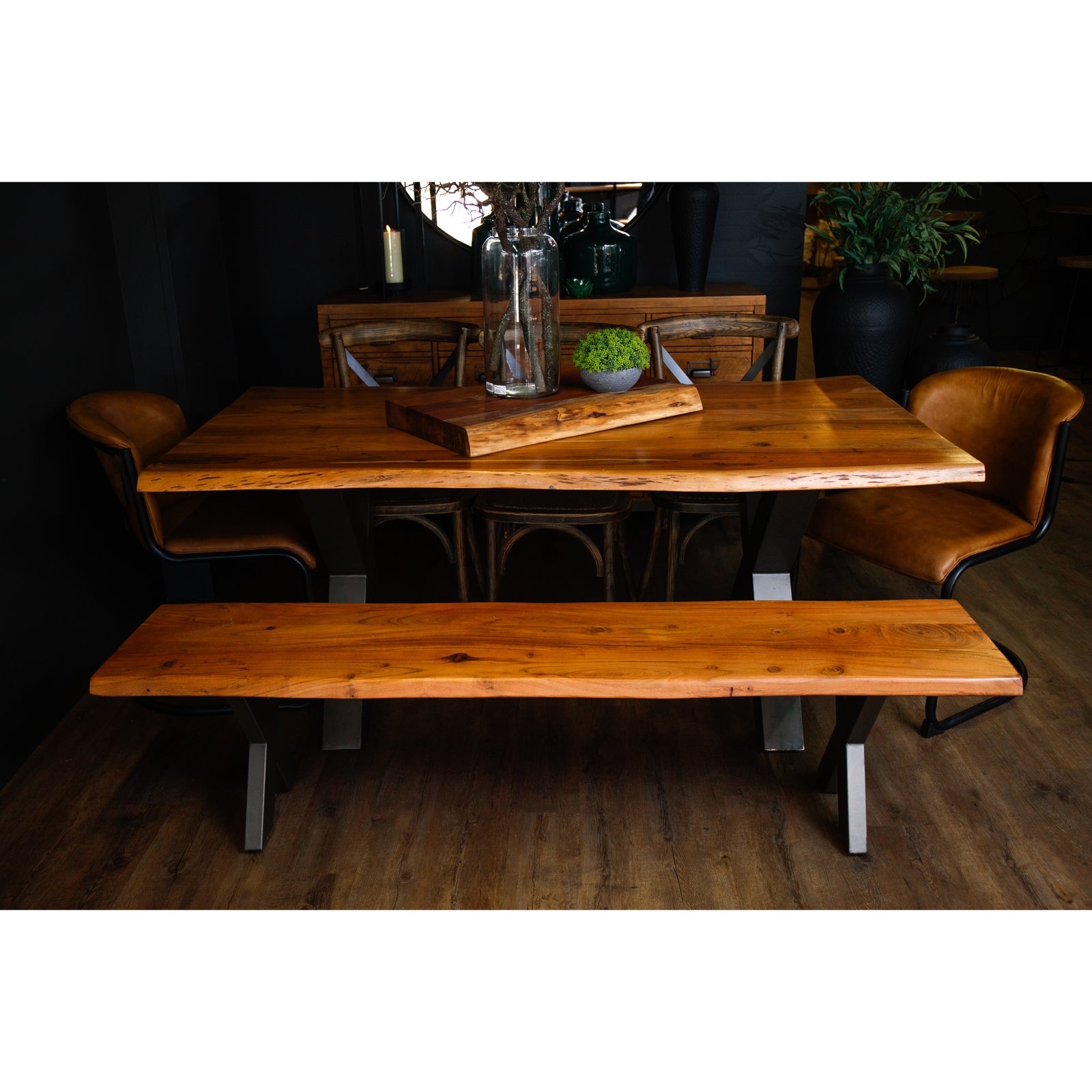 Large live edge dining table made of Indian acacia wood with industrial metal legs, surrounded by stylish seating.