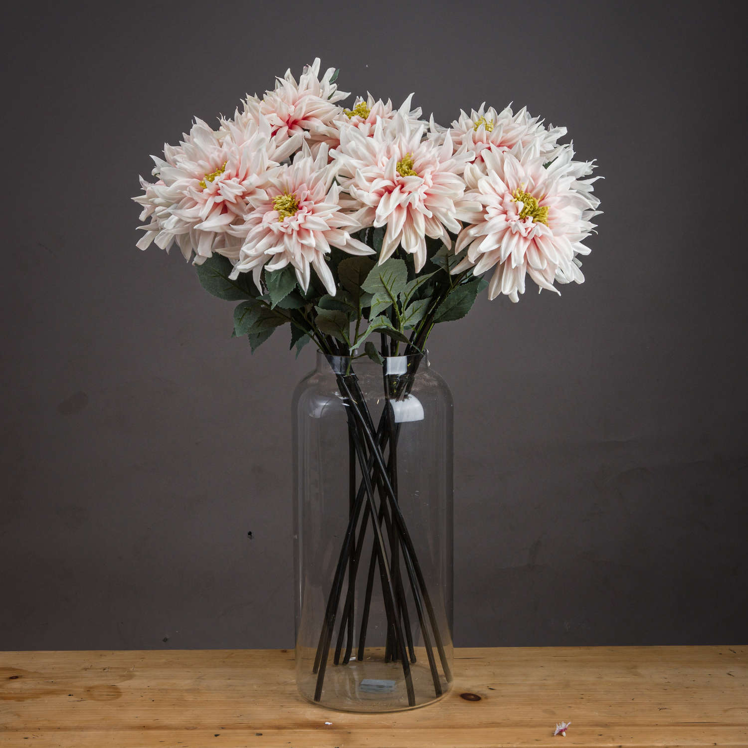 Lush pink dahlia artificial flowers in a clear vase, showcasing lifelike petals and green foliage for elegant decor.