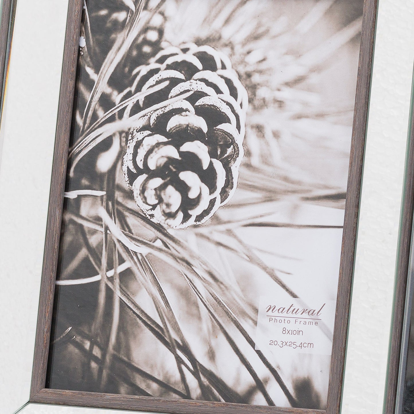 Elegant 8x10 photo frame featuring a rich wood border and reflective glass, displaying a monochrome pinecone image.