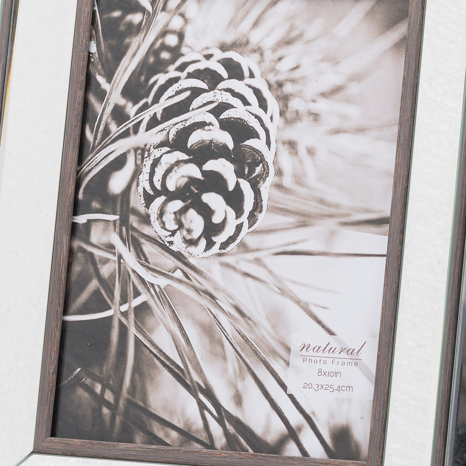 Elegant 8x10 photo frame featuring a rich wood border and reflective glass, displaying a monochrome pinecone image.