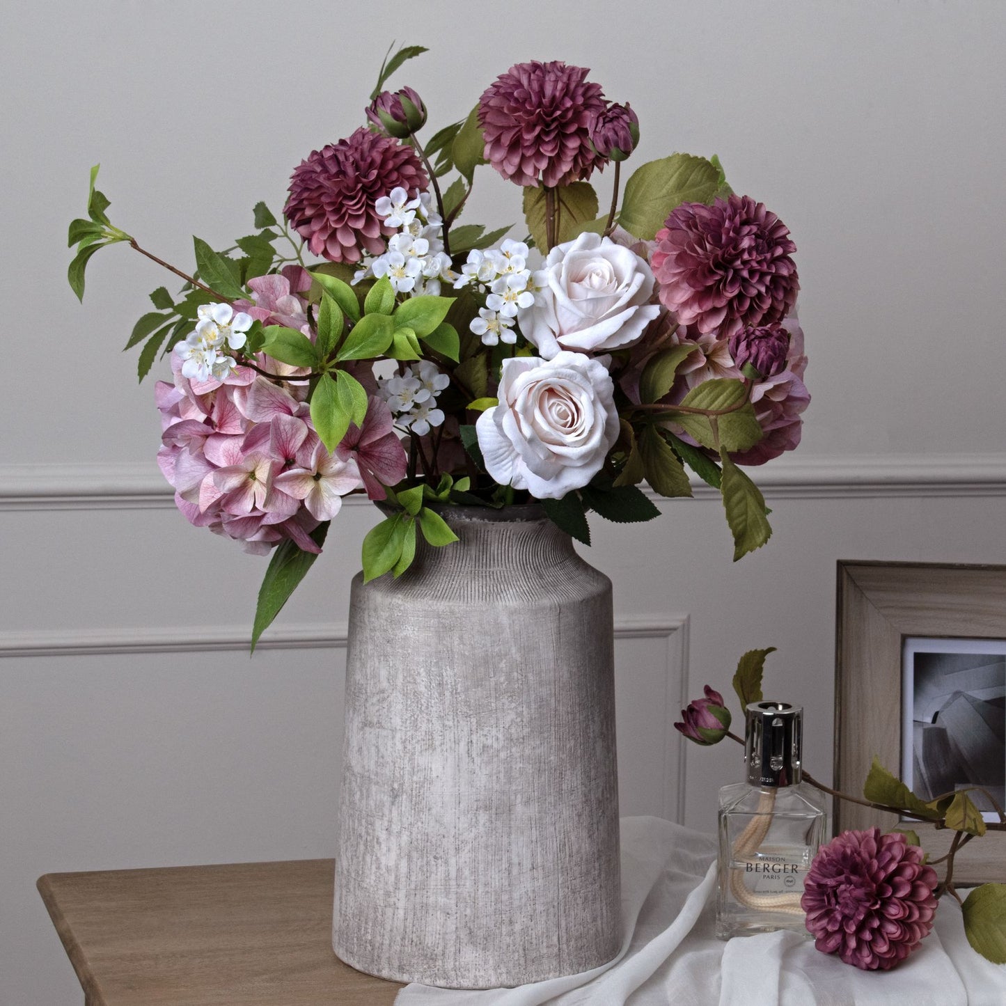 Shabby pink hydrangea among white roses and dahlias, arranged in a textured gray vase, offering a romantic, elegant decor touch.