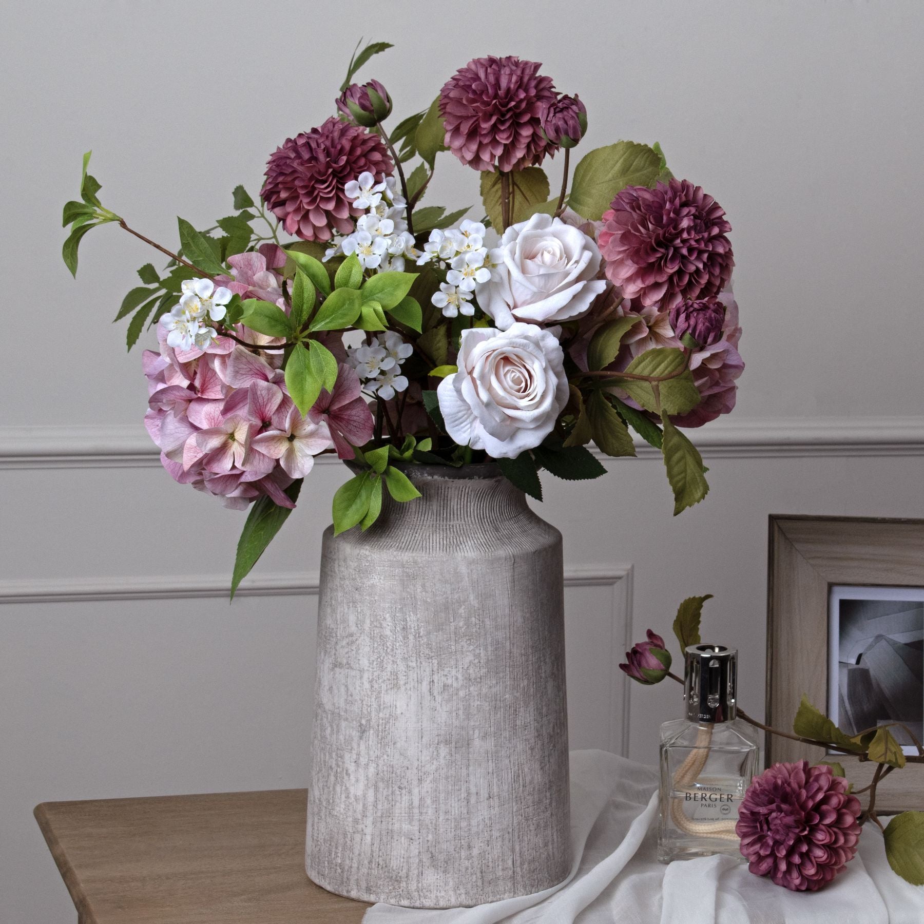 Shabby pink hydrangea among white roses and dahlias, arranged in a textured gray vase, offering a romantic, elegant decor touch.