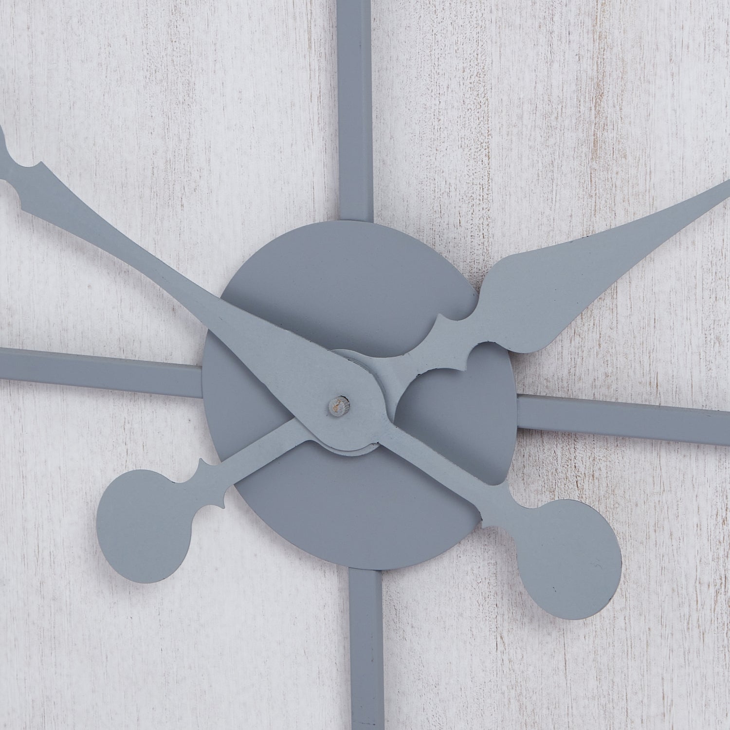 Multi-paneled wall clock with sleek gray hands, set against a textured white background, combining modern elegance and functionality.