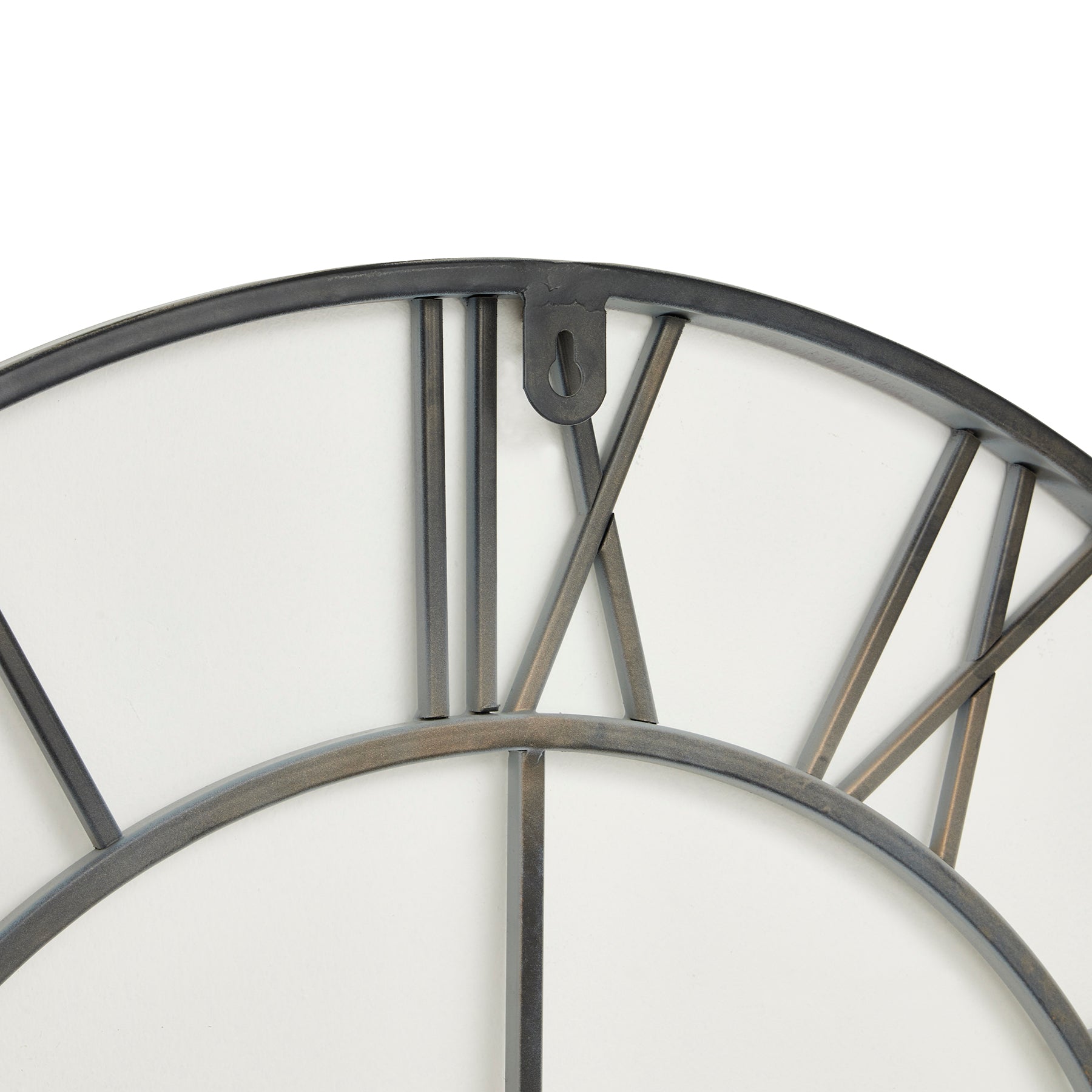 Oversized grey skeleton wall clock with elegant Roman numerals, minimalist metal design, creating captivating shadows for modern interiors.