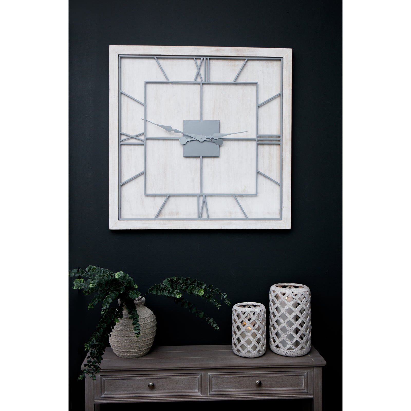 White square wall clock featuring a white-washed wooden frame, light grey Roman numerals, and an open skeleton-style design.