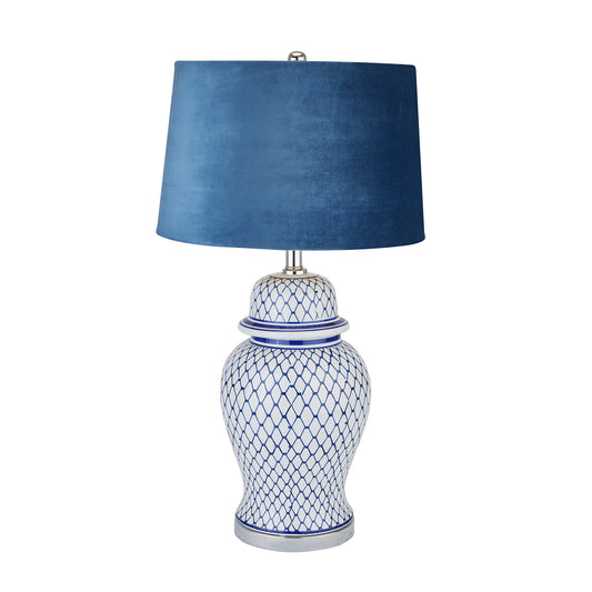 Ceramic lamp with a ginger jar silhouette, featuring intricate blue and white patterns and a luxurious blue velvet shade.
