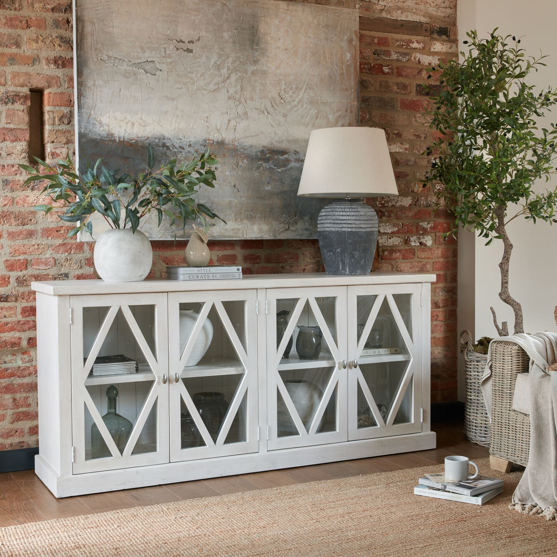 Sleek, contemporary globe vase in soft white, elegantly displaying faux flowers atop a rustic wooden console with warm tones.