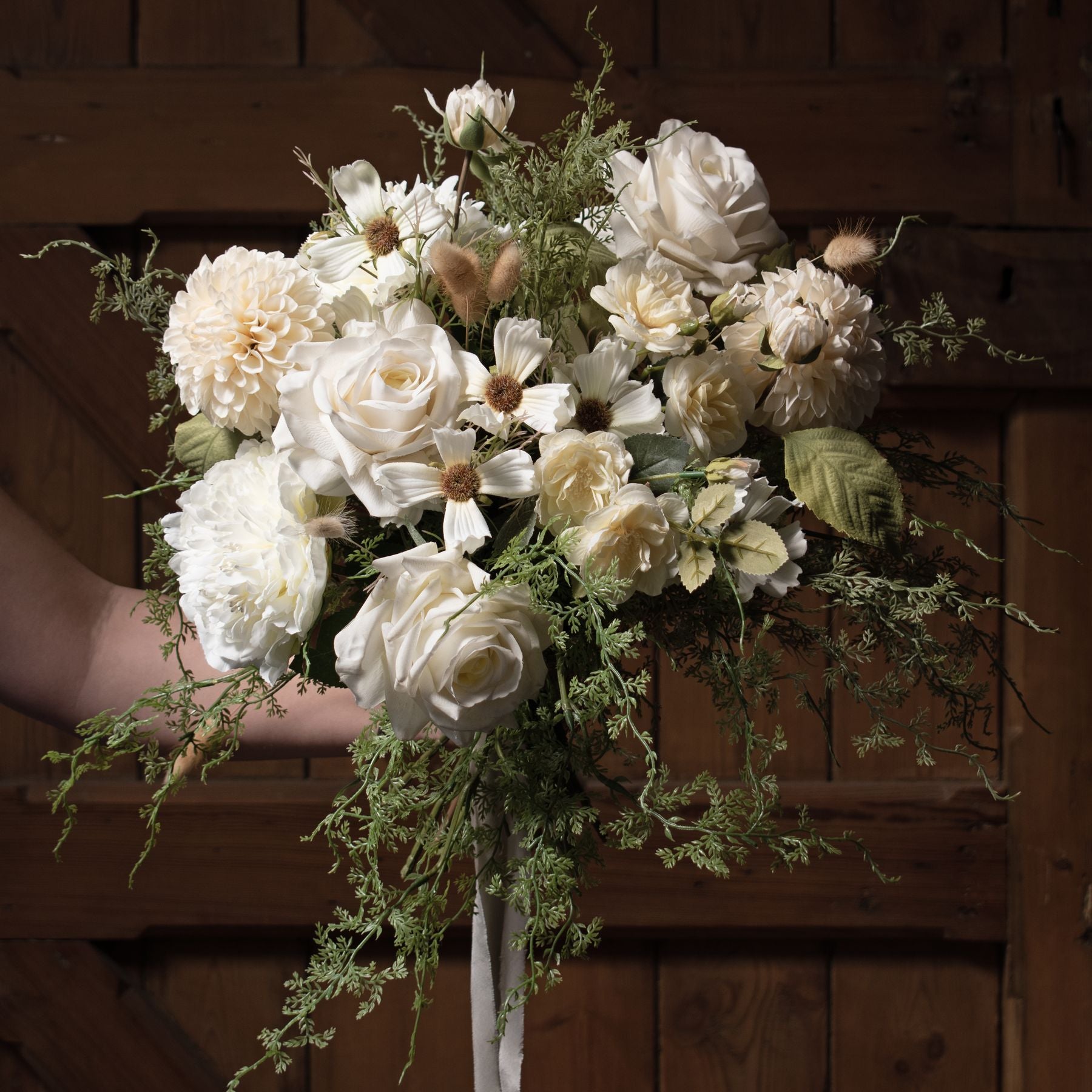 Elegant white dahlia stem featuring layered petals, surrounded by muted blooms and greenery, perfect for minimalist decor.