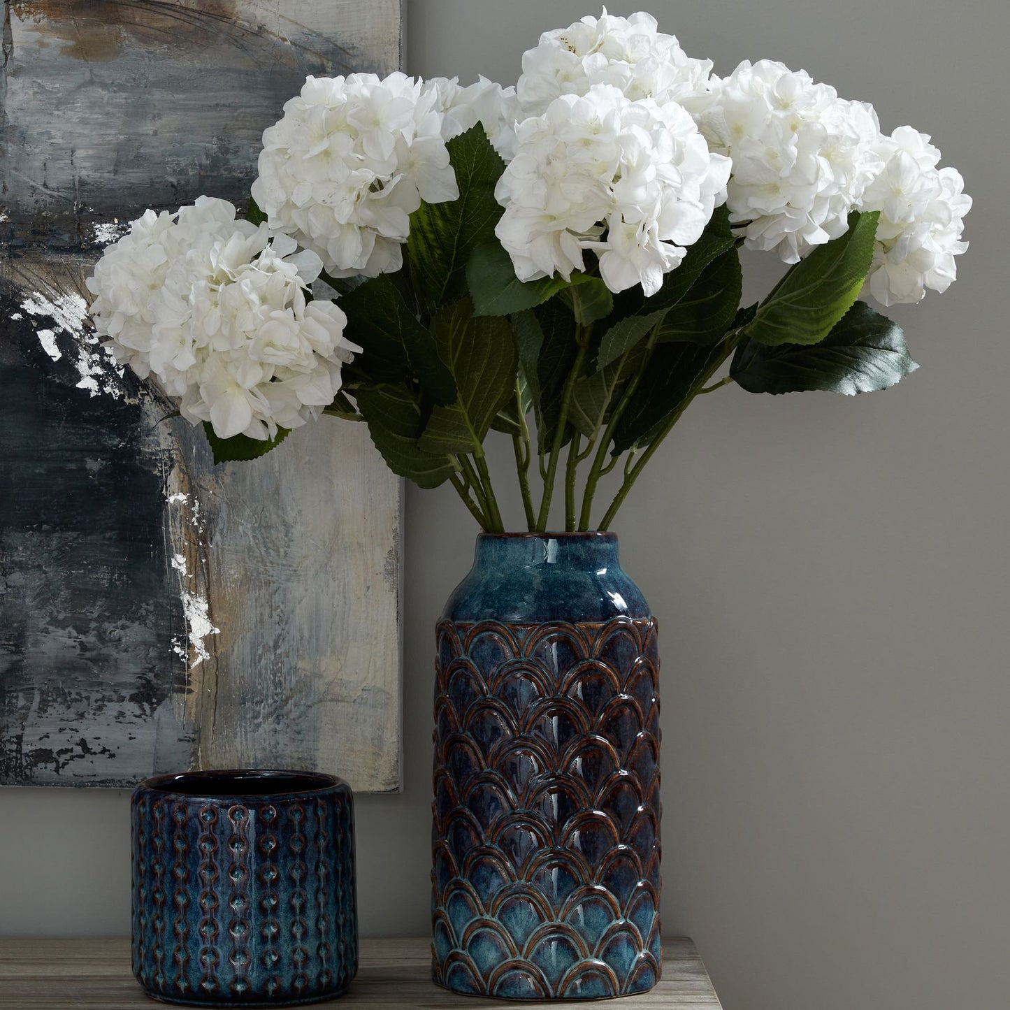 Indigo planter with a textured, glossy finish, accented by white hydrangeas, adding coastal elegance to any interior.