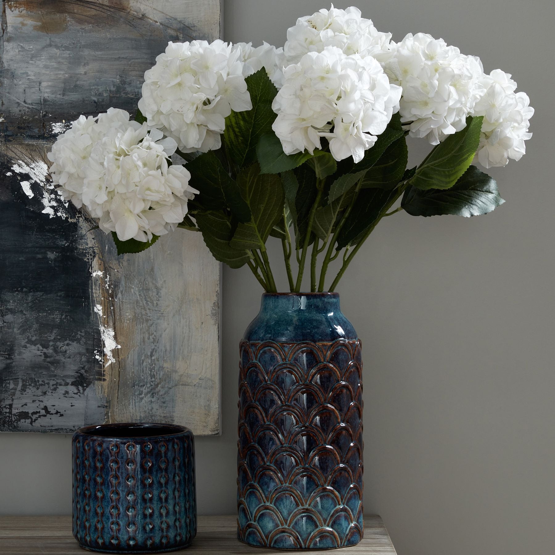 Indigo planter with a textured, glossy finish, accented by white hydrangeas, adding coastal elegance to any interior.