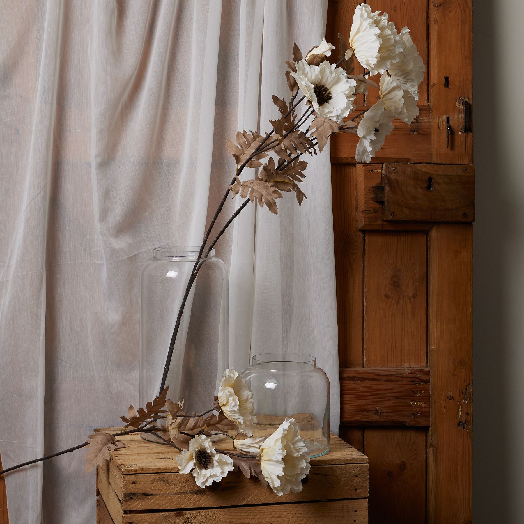 Large white poppy stem with intricate blooms and subtle coffee accents, artfully arranged with natural foliage.