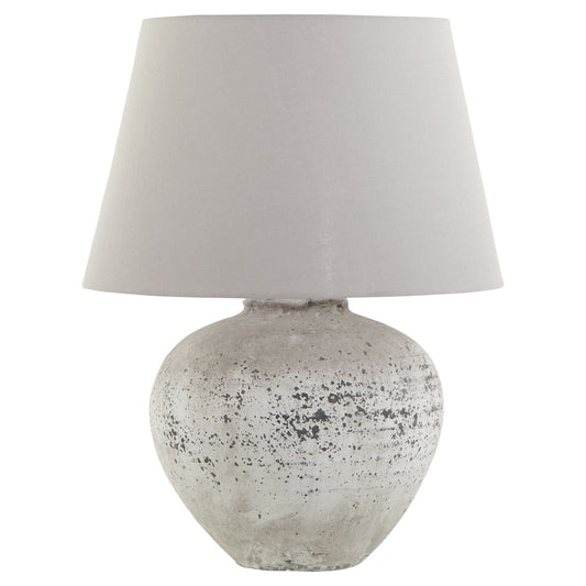 Red ceramic lamp with a rustic stone-effect base, speckled detailing, and a light gray fabric shade, creating a warm ambiance.
