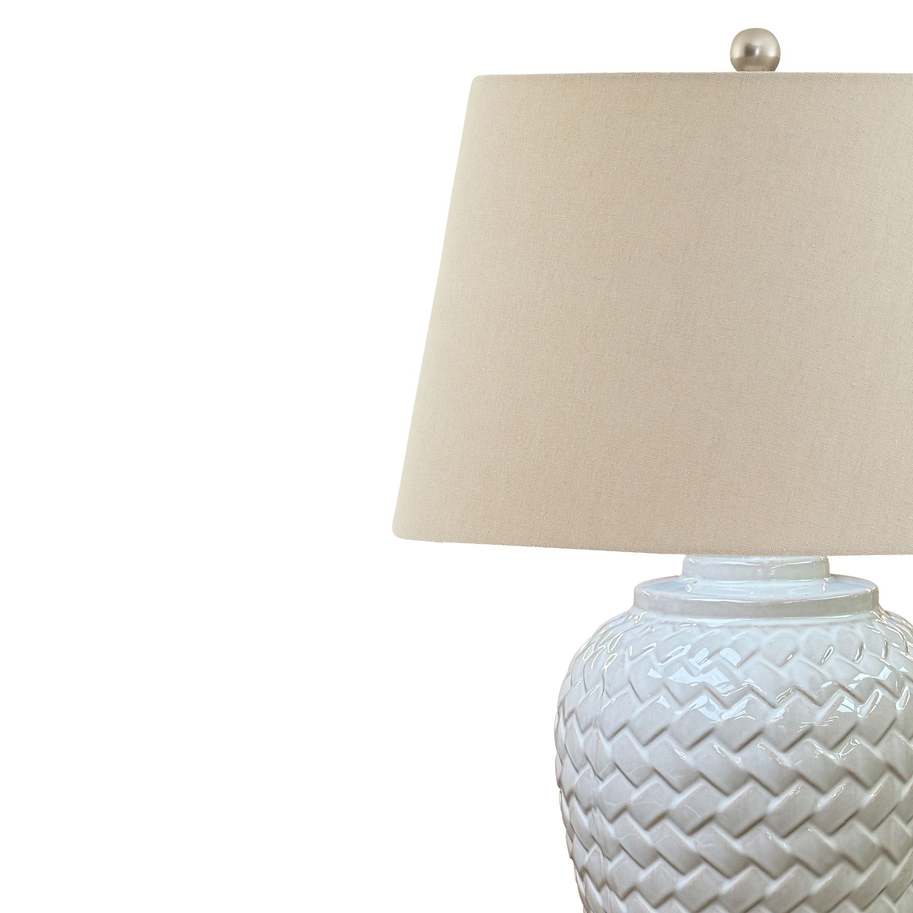 Woven ceramic table lamp with white chevron pattern and a soft linen shade, providing elegant illumination for any space.