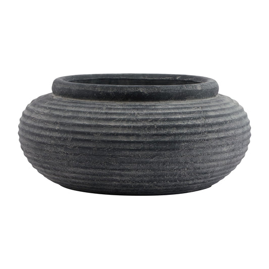 Round grey planter with textured ribbing and a weathered finish, ideal for displaying large indoor plants.
