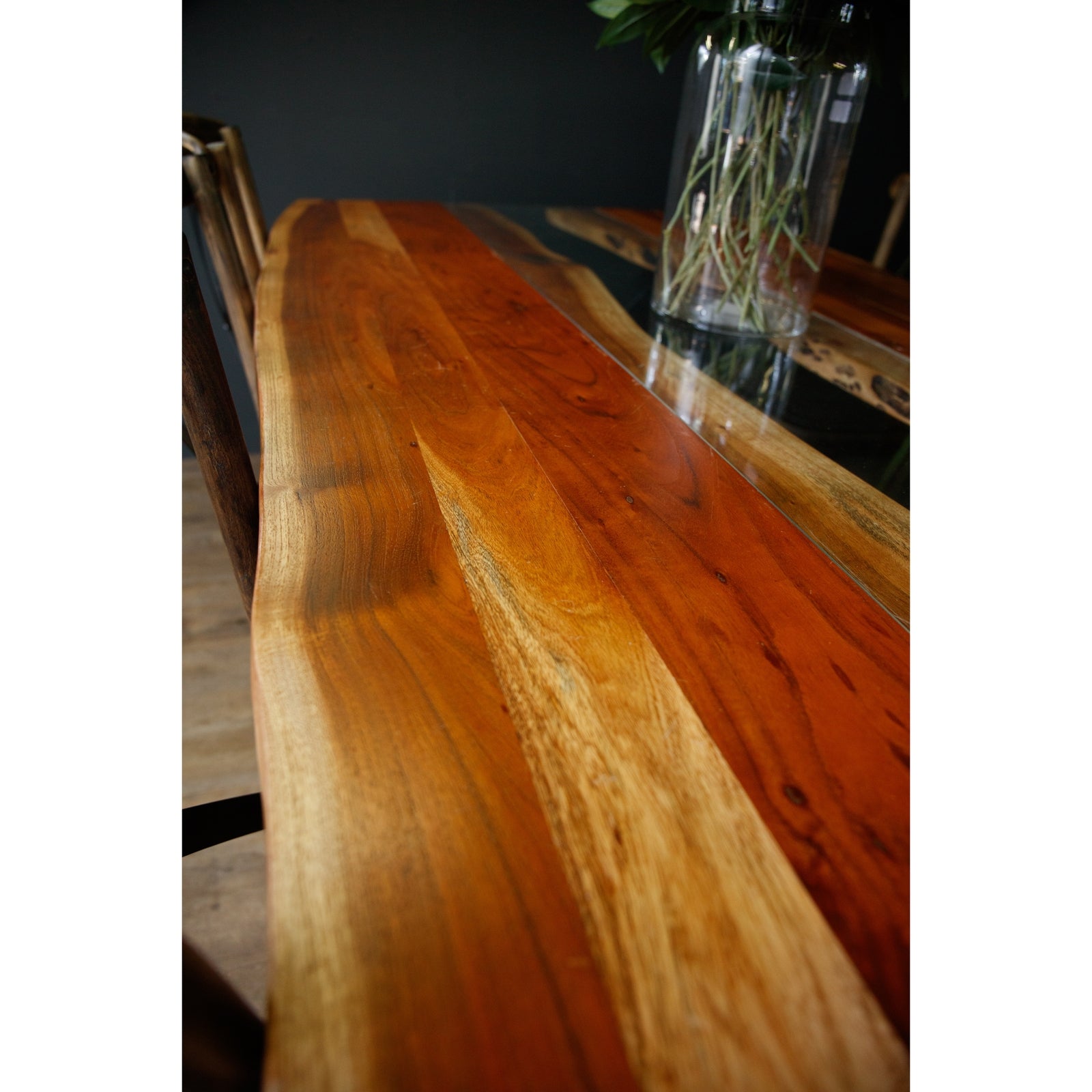 Large live edge dining table made from solid Acacia wood, featuring a glass river inlay and warm, natural tones, enhancing sophistication.