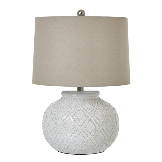 White ceramic lamp features intricate beaded design and a soft beige linen shade, perfect for coastal or boho decor.