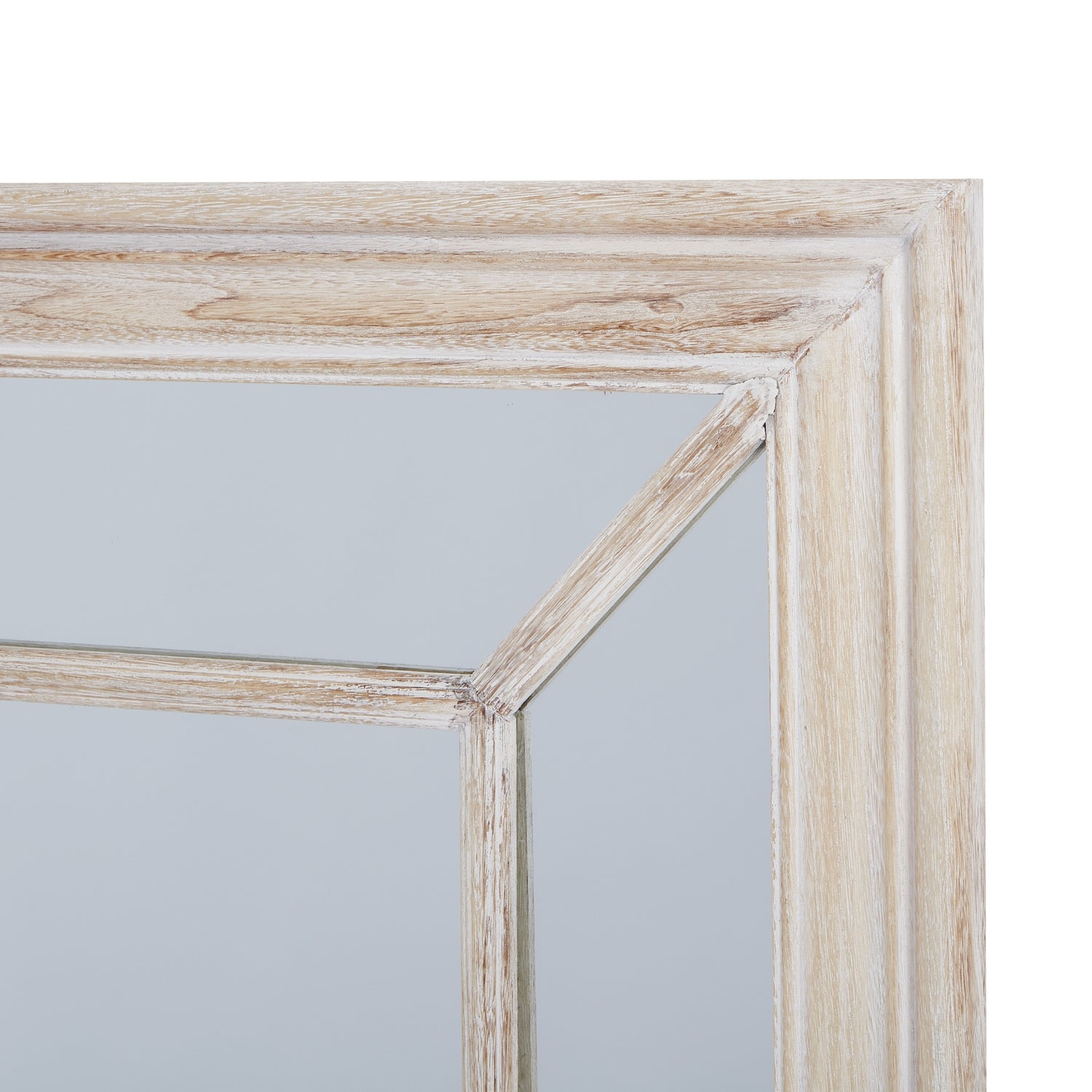 Rustic washed wood-framed mirror with an architectural window pane design, reflecting light in a warm, inviting tone.